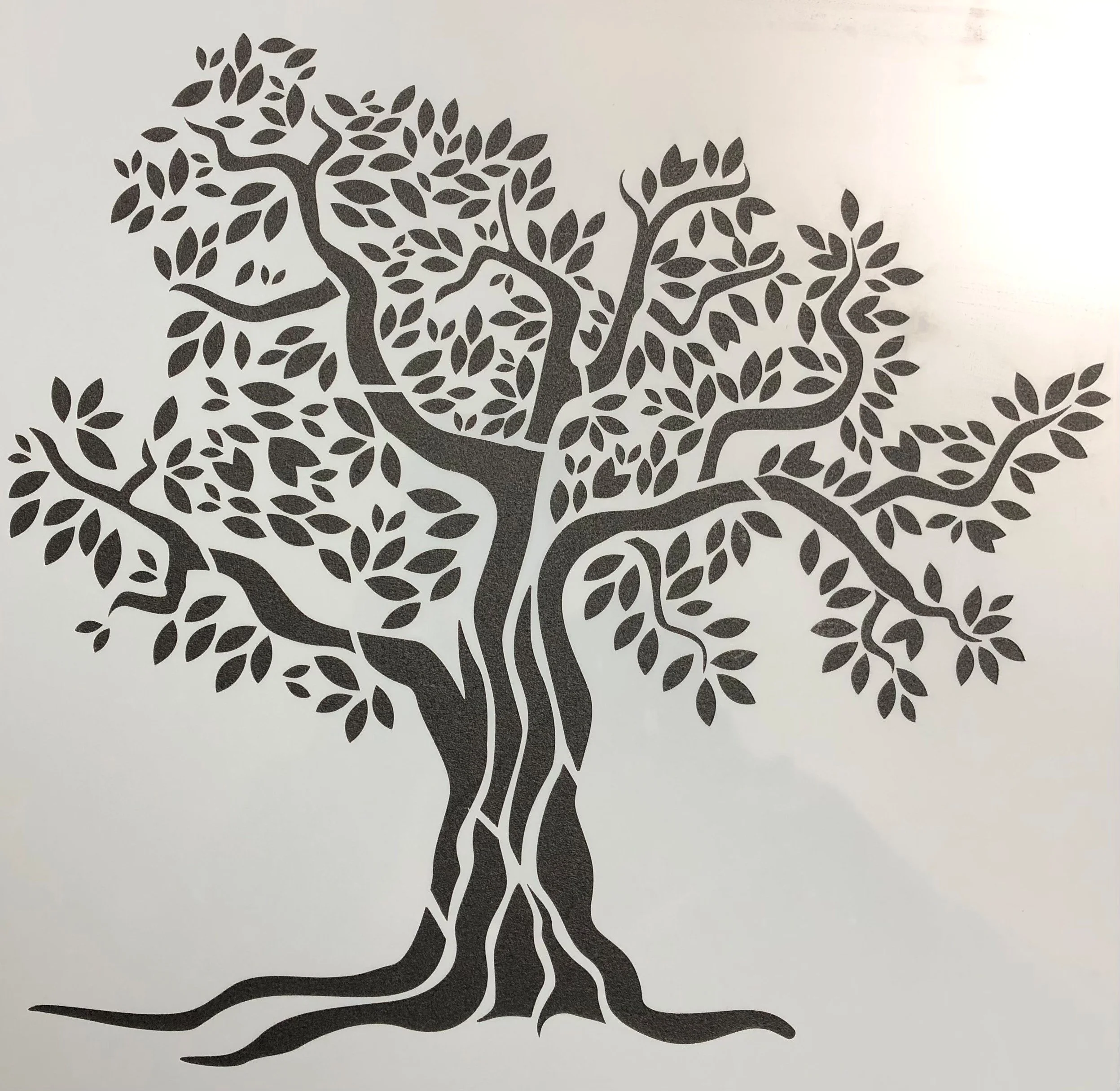 Black silhouette of a tree of life with many branches and leaves on a white background.