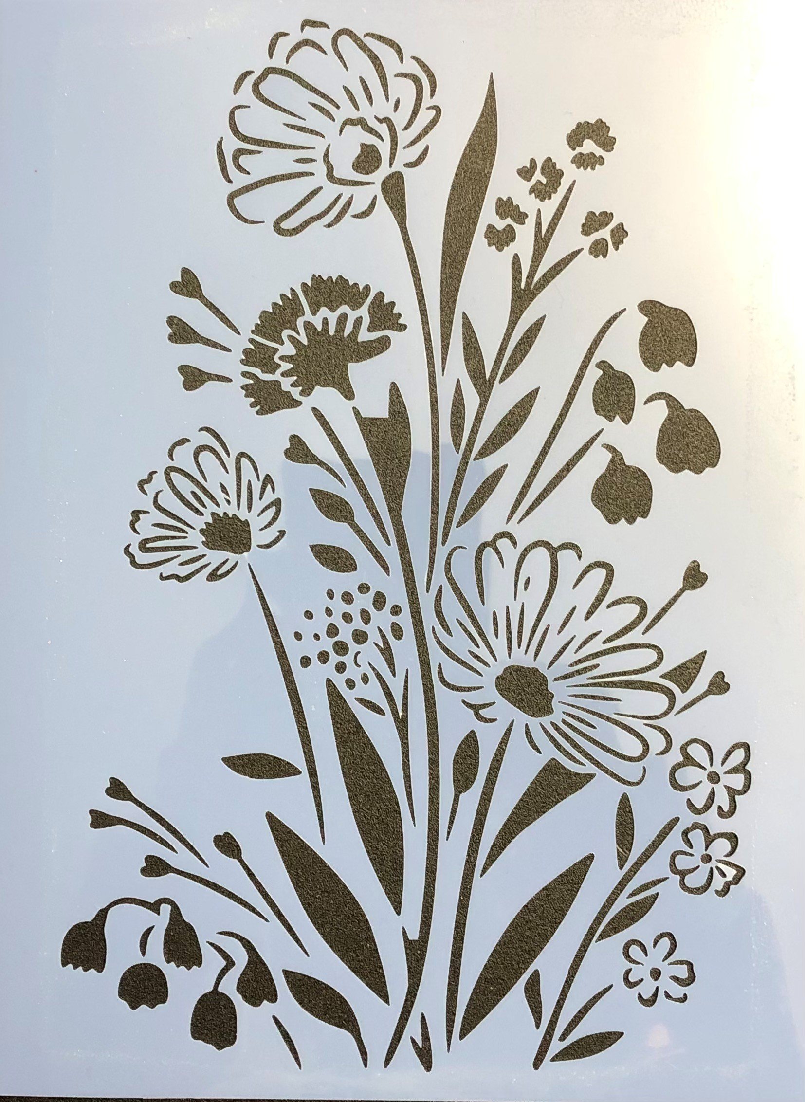 Silhouette of various flowers and leaves arranged in a floral pattern.