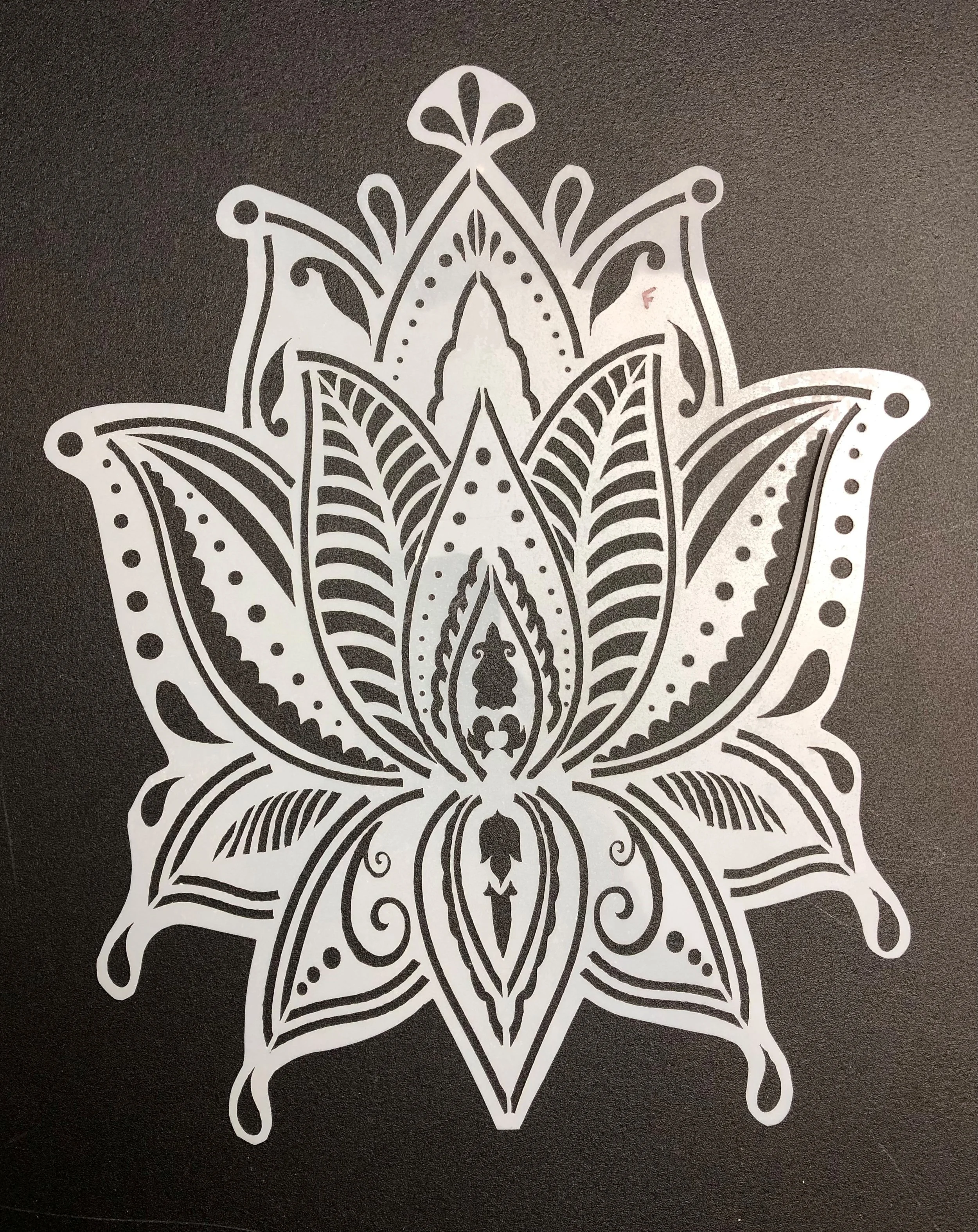 Black and white intricate floral or mandala design with symmetrical patterns and detailed line work.