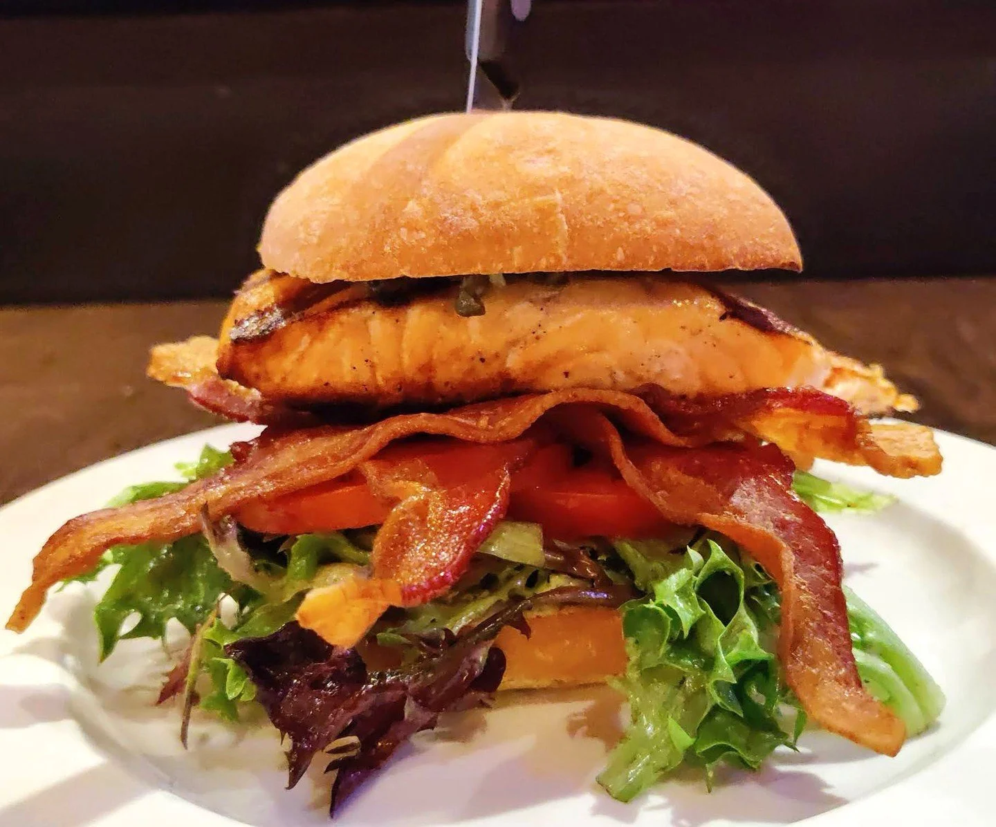 🥪 SALMON B.L.T.: grilled salmon, bacon, mixed greens tossed in bacon cider vinaigrette, tomatoes, fried capers, and walnut-pesto mayo, served on ciabatta.🐟

 #CrowsNestSTL #MaplewoodMO #SalmonBLT #GastropubEats #ComfortFood #StLouisEats