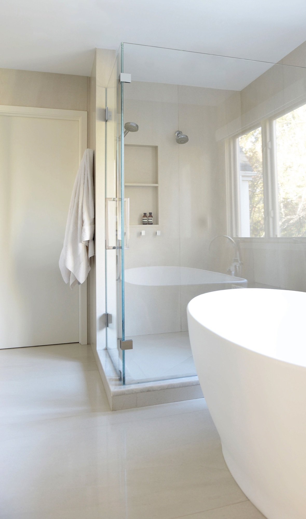 Glass shower beside the freestanding tub