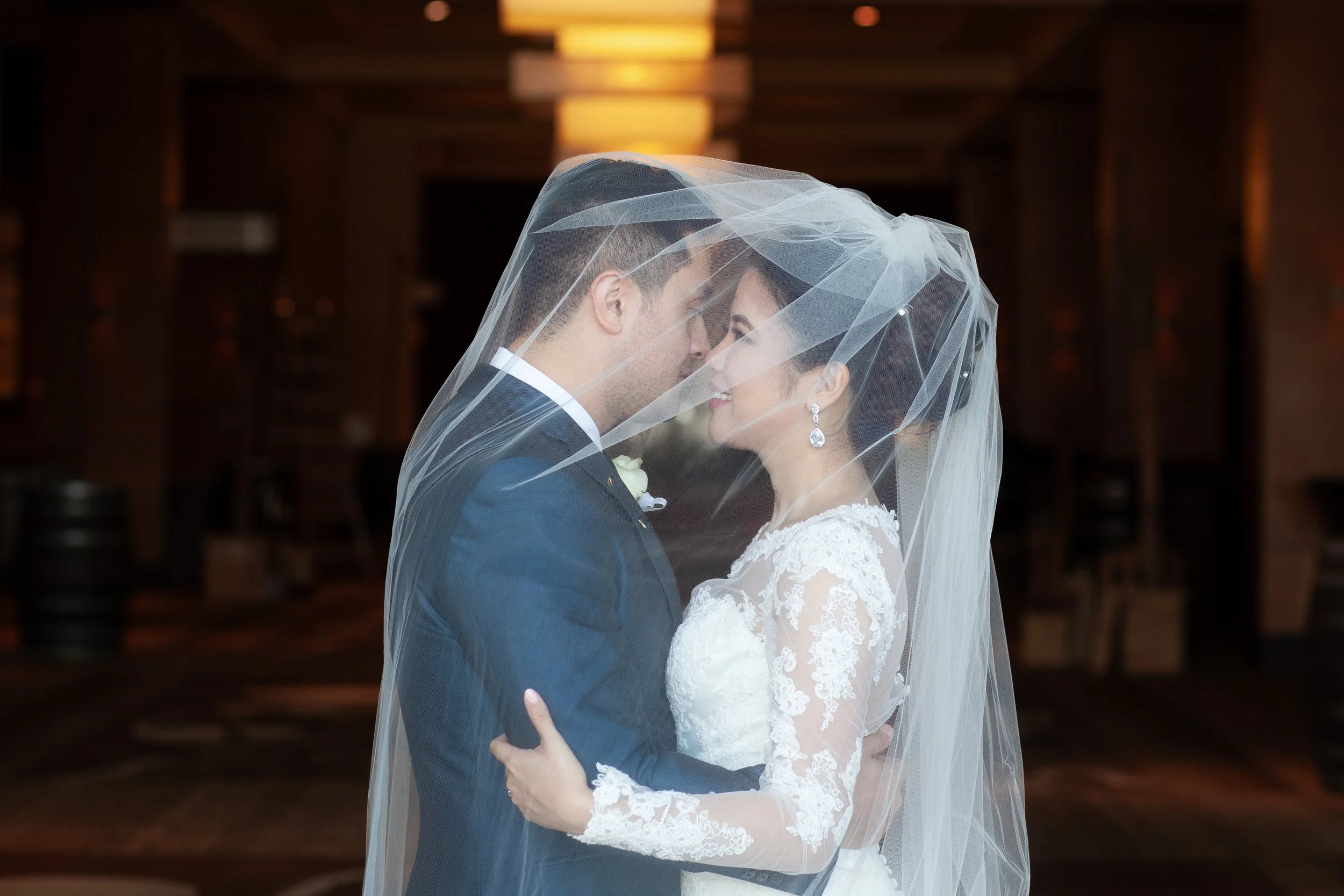 bride and groom embrace under veil, bellevue hyatt hotel