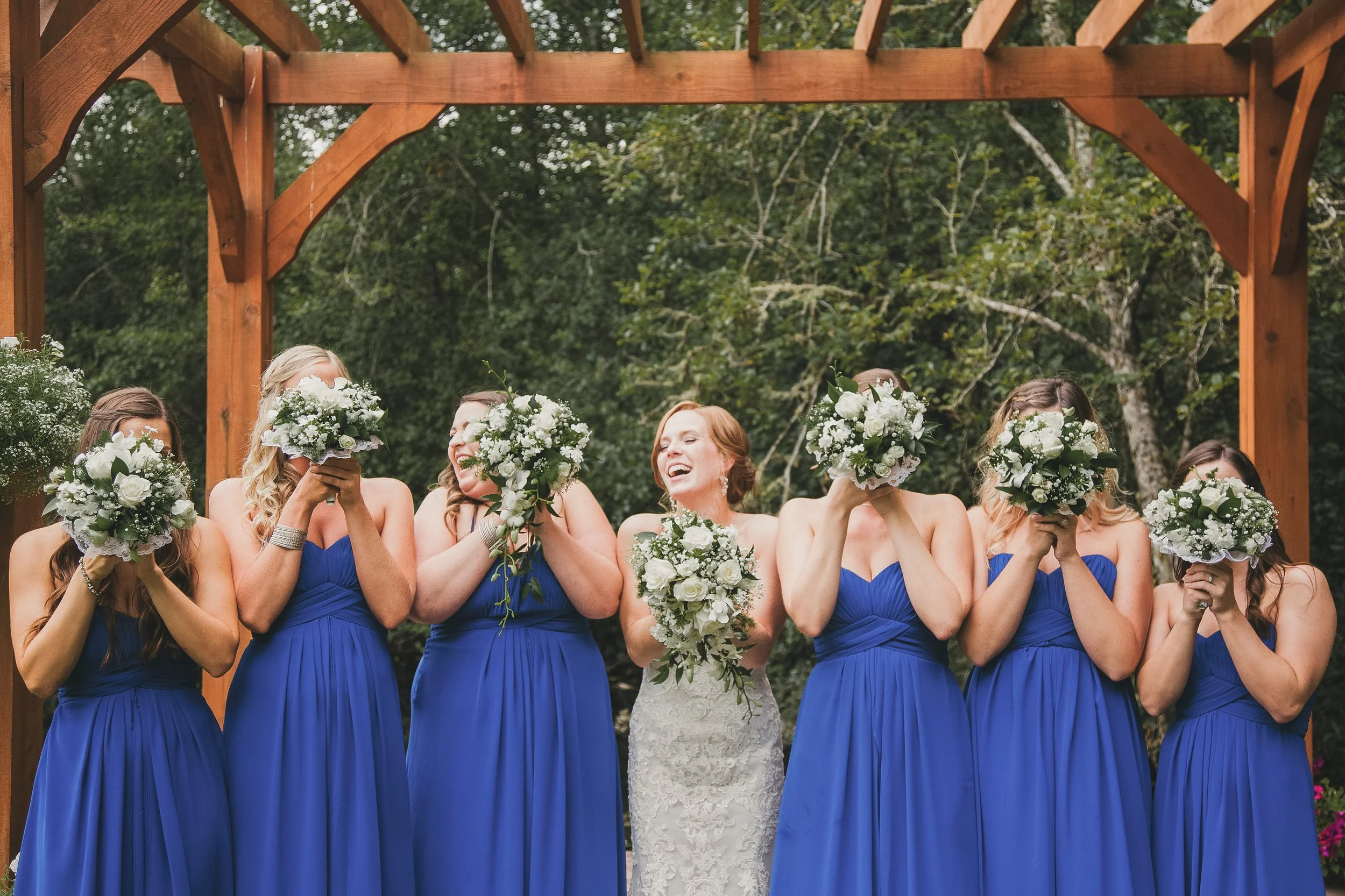 cedar springs weddings and events, bride, bridal party, laugh behind floral bouquets
