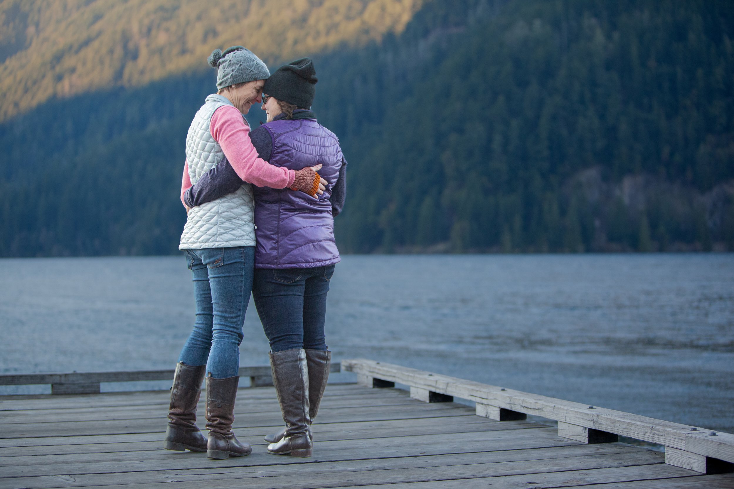 olympic peninsula, two brides embrace at the shore of lake crescent, elopement, ceremony, gay wedding, pride, lesbian wedding