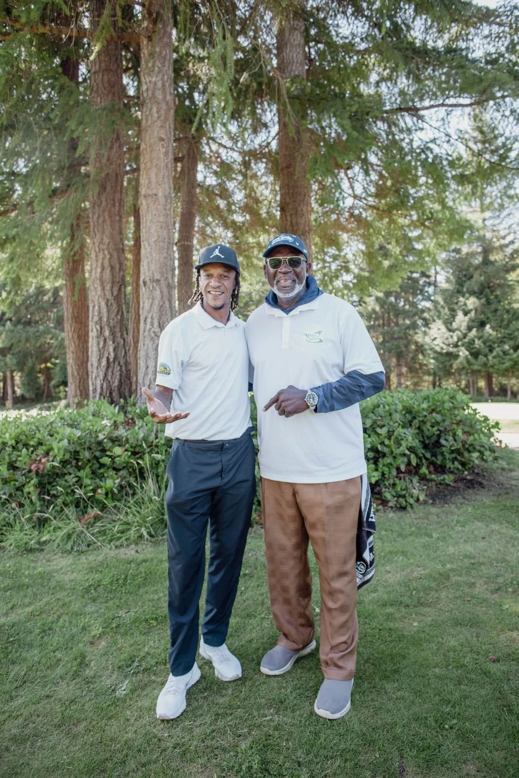 Alonzo Mitz is a retired NFL player for the seahawks. standing next to Brian hunter who played major league baseball with the seattle mariners. A candid moment captured on the golf course between two friends smiling at the camera