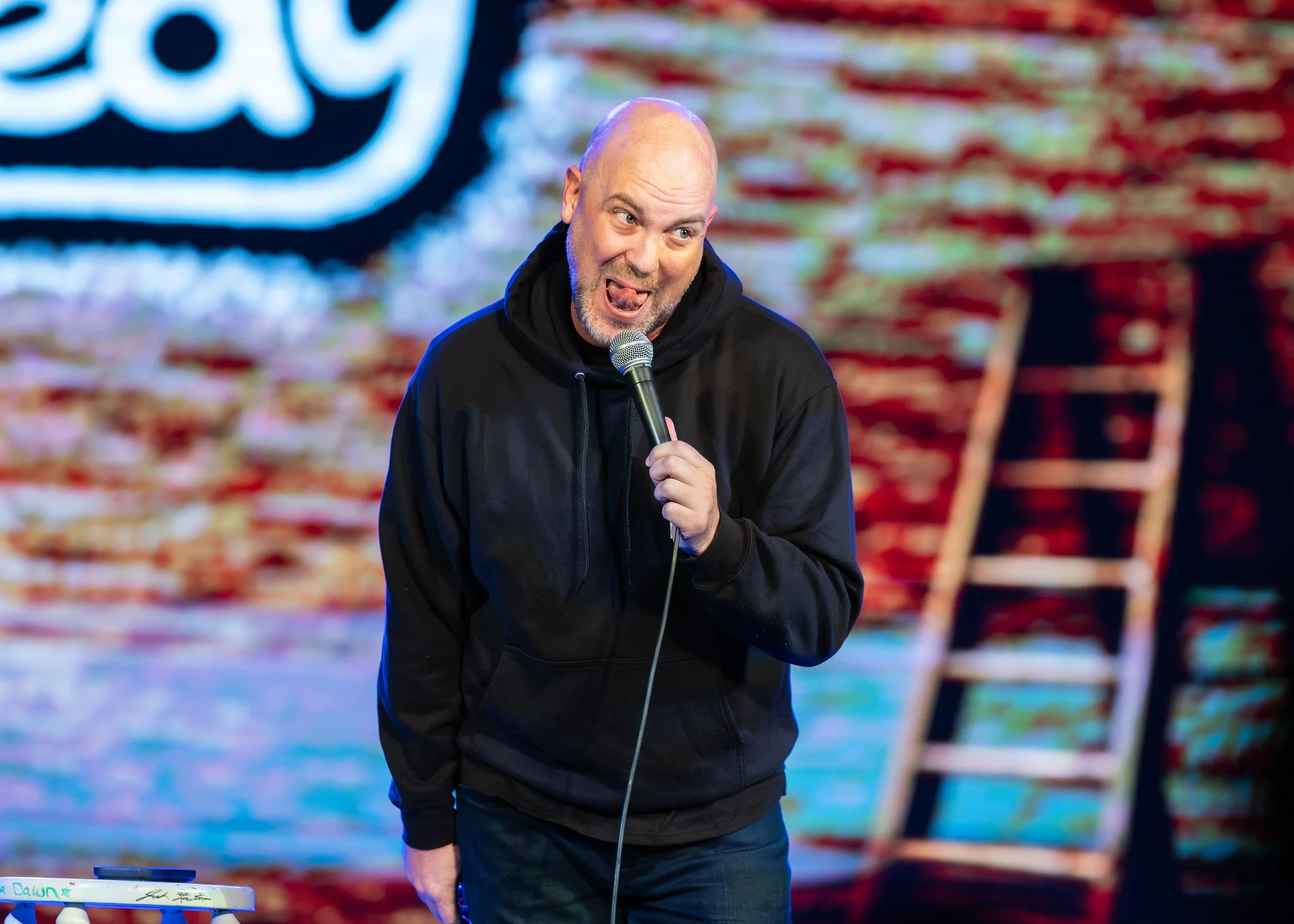 cory michaelis makes a silly face on stage at the new everett theater hosting for everett comedy