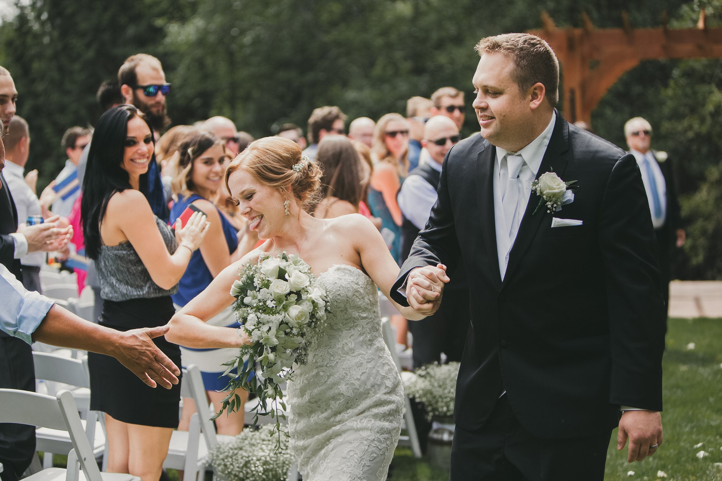 cedar springs, wedding, ceremony, recessional, bride offers a high five to guest as she leaves the ceremony