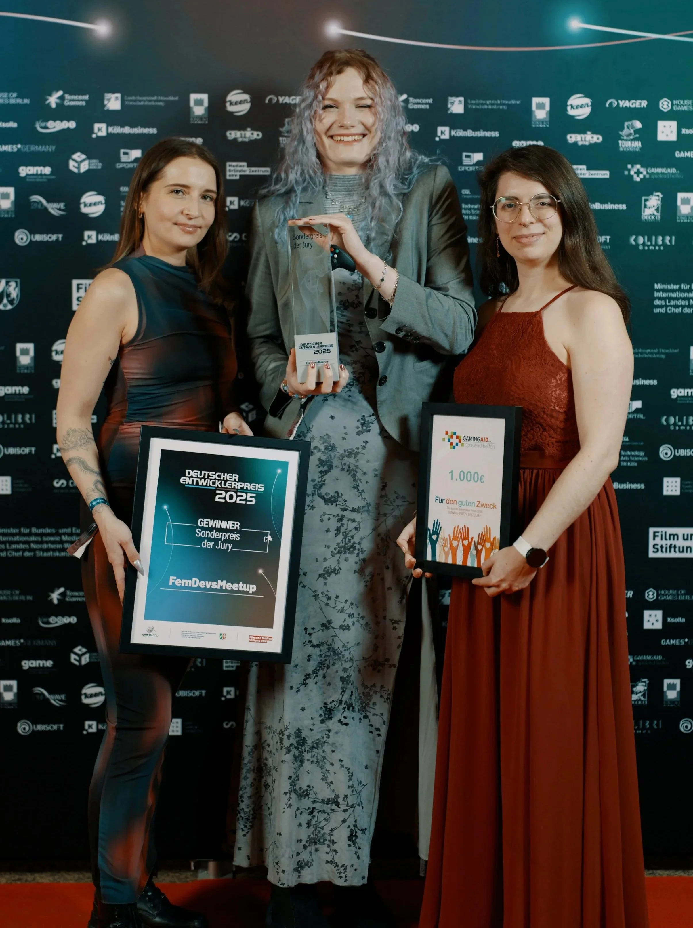From left to right: me, my colleagues Janna and Anna are showing our award and smiling for the camera in evening gowns.