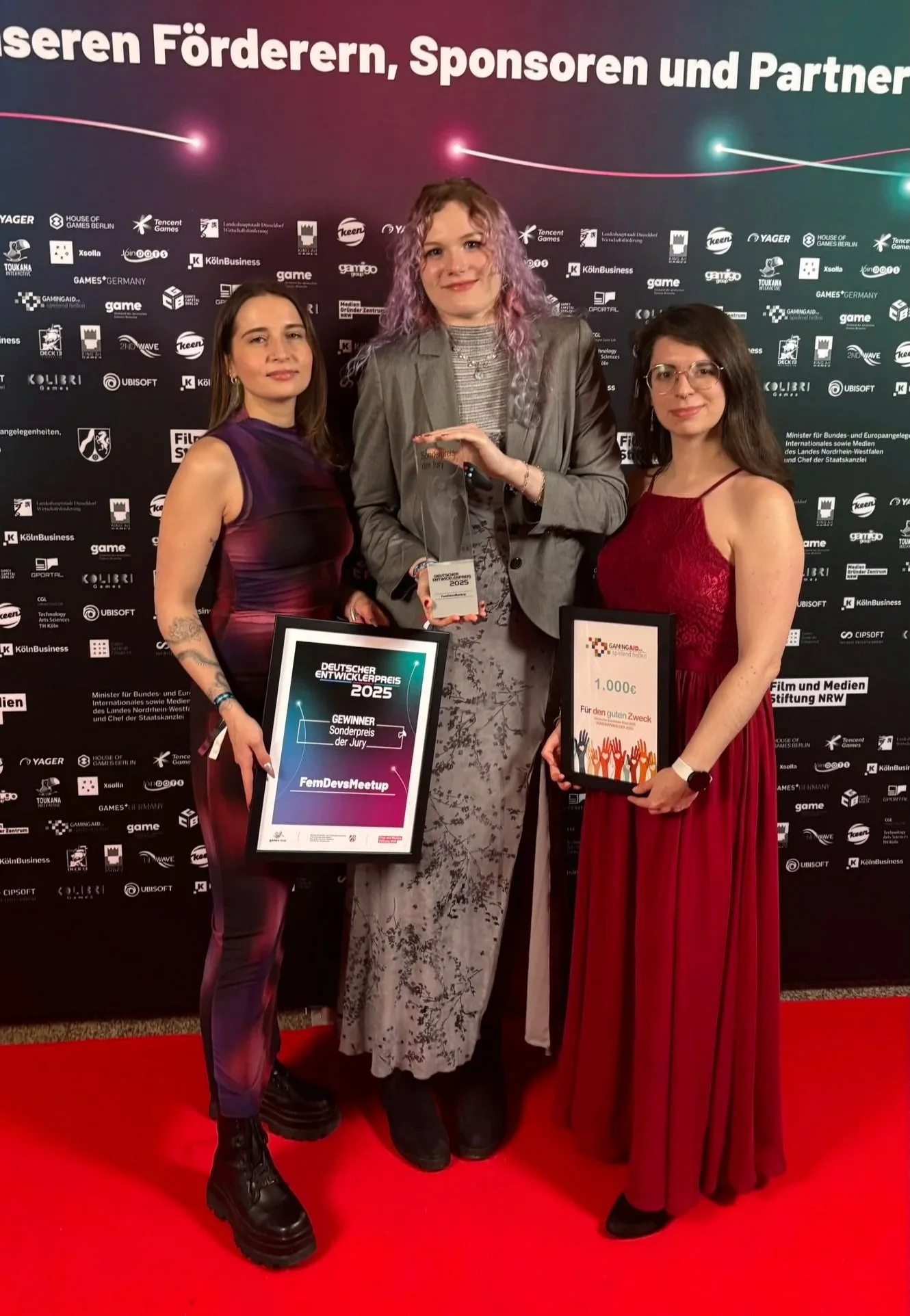 From left to right: me, my colleagues Janna and Anna are showing our award and smiling for the camera in evening gowns.