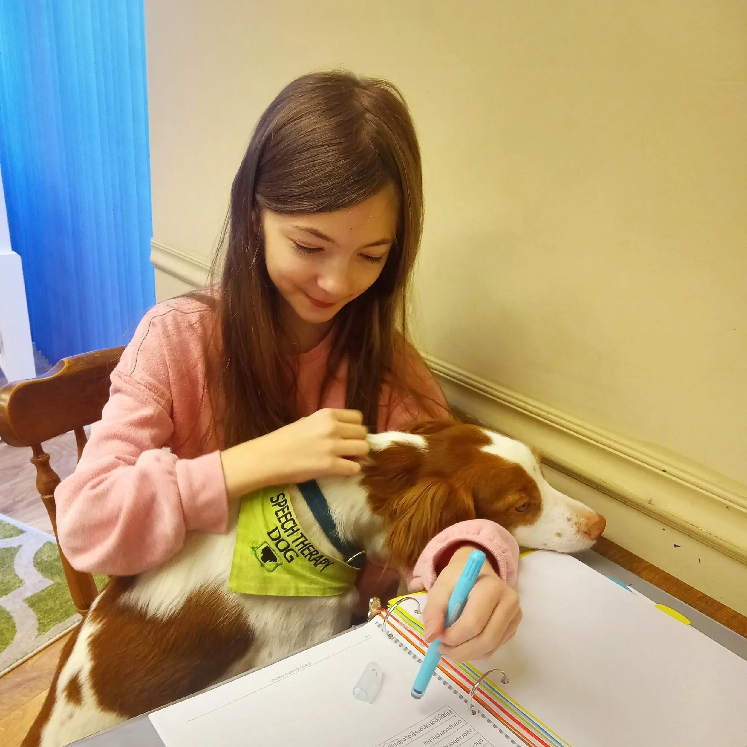 Sky in lap of child during animal-assisted reading therapy.