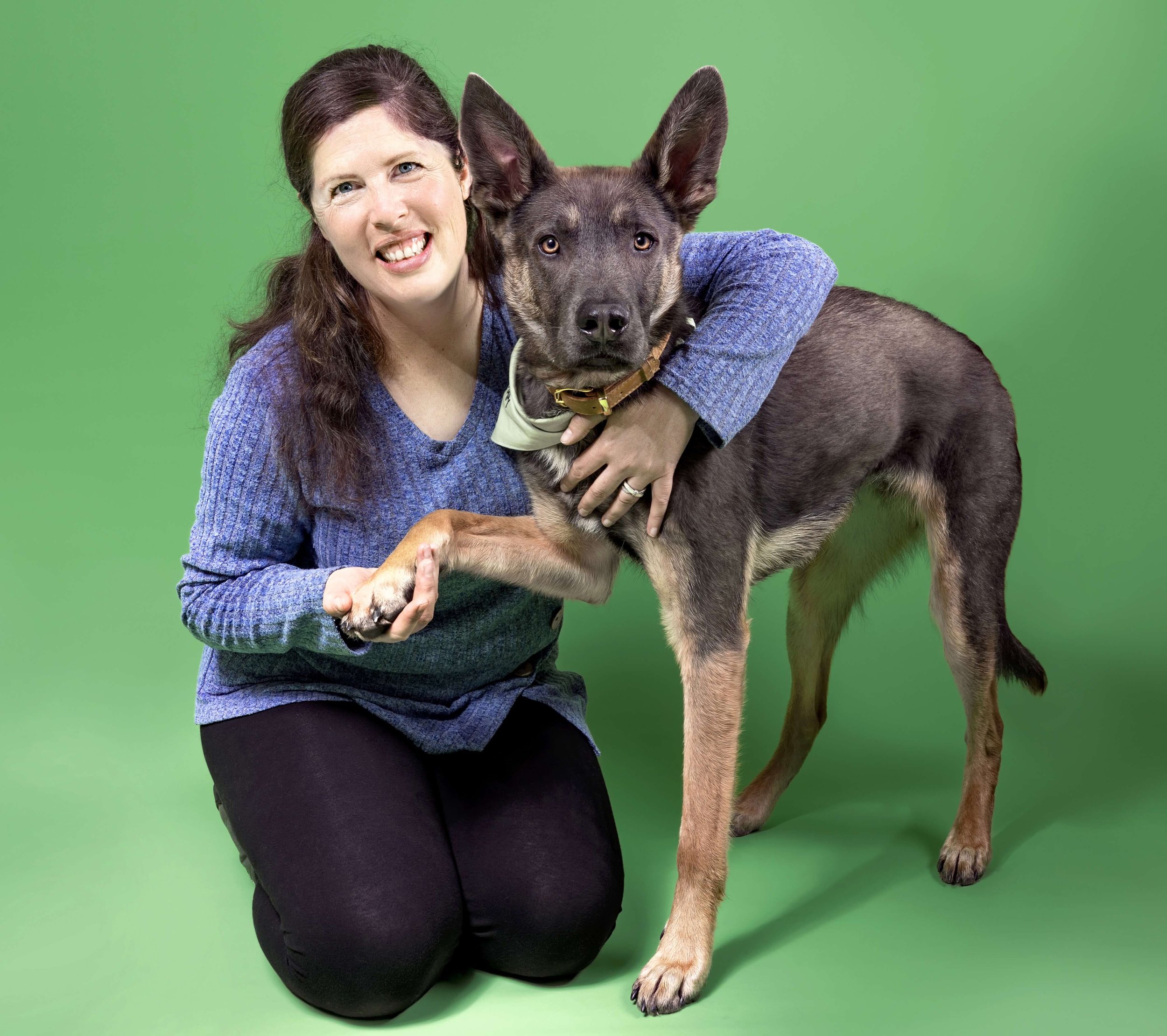 Canine-assisted intervention specialist Sharlet holds speech therapy dog Zephyr's paw.