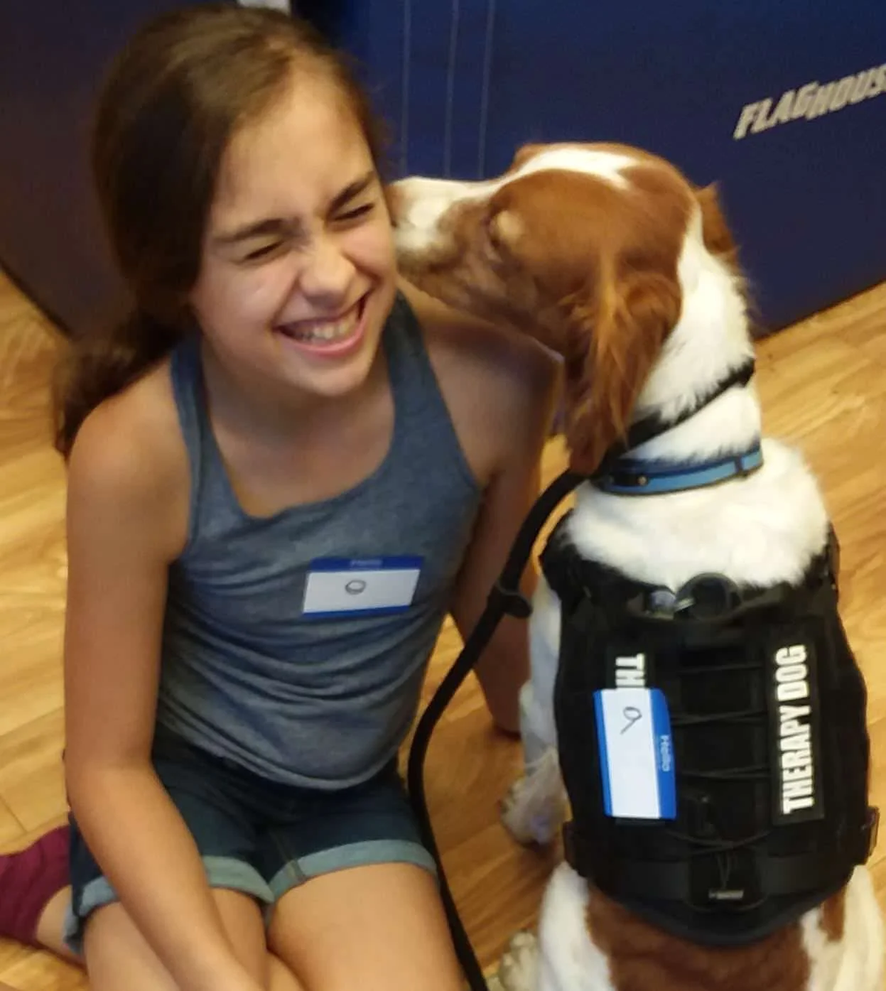Speech therapy dog kisses child in animal-assisted speech therapy.
