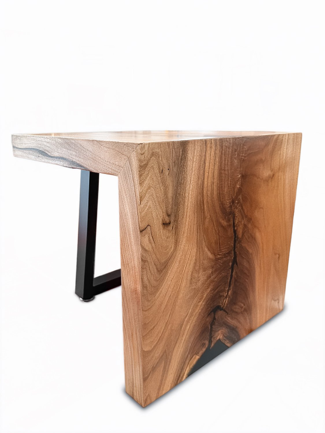 A modern desk made of a thick, live-edge wood slab and black metal legs.