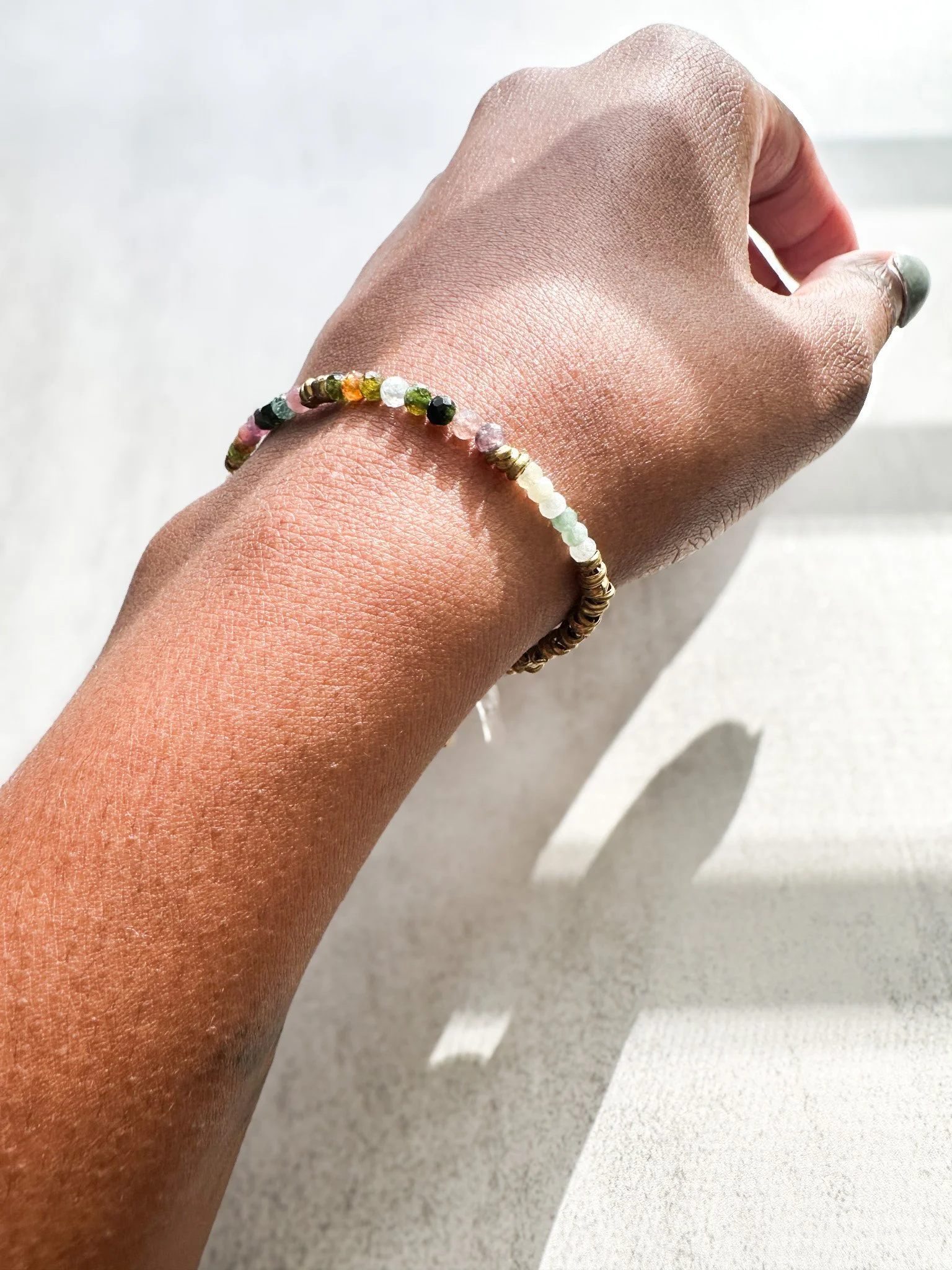 Arden natural gemstone bracelet on wrist in sunlight, close-up of gemstone beads