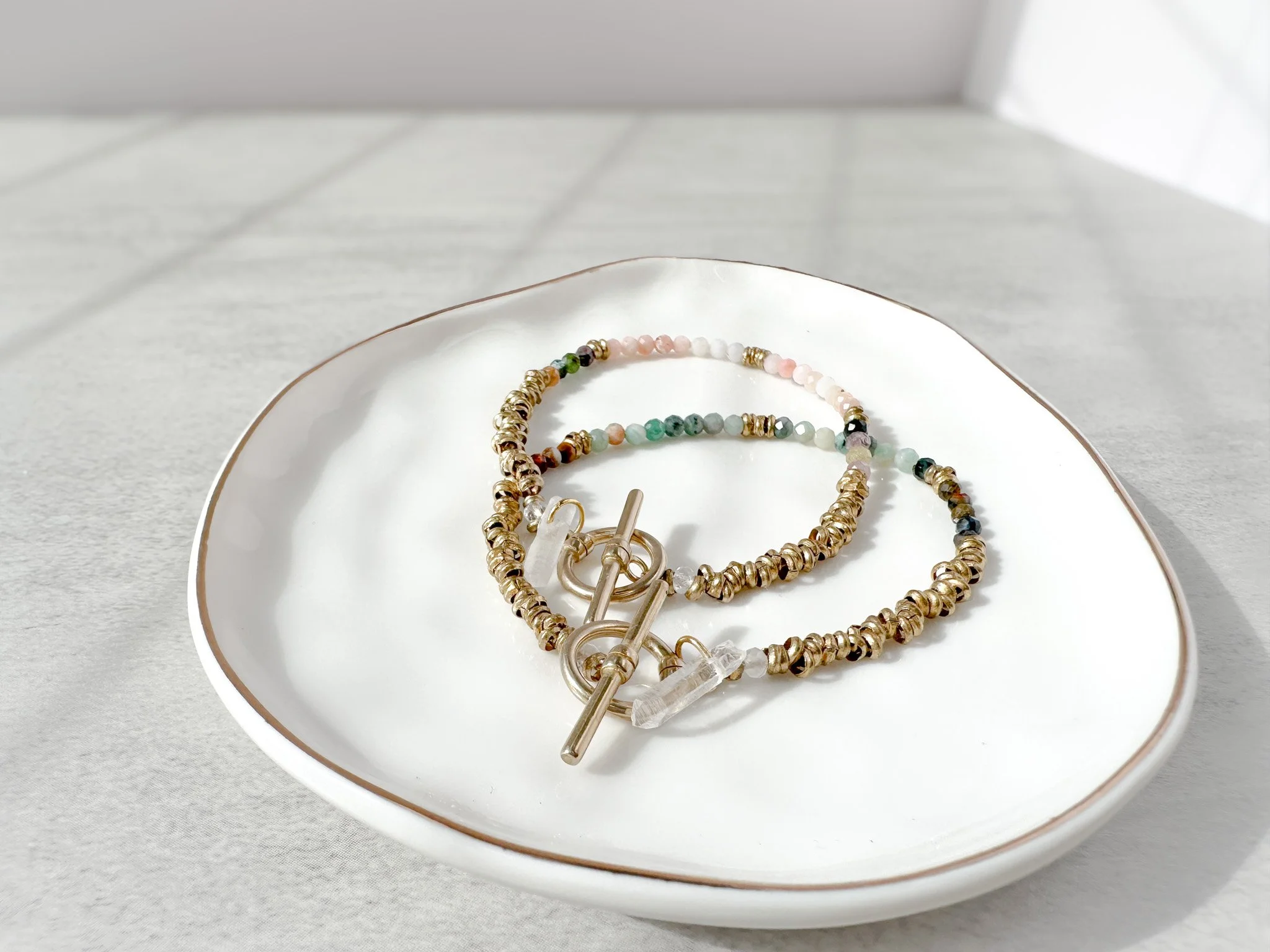 Aurora bracelet stack on dish with pink opal, watermelon tourmaline and rainbow moonstone