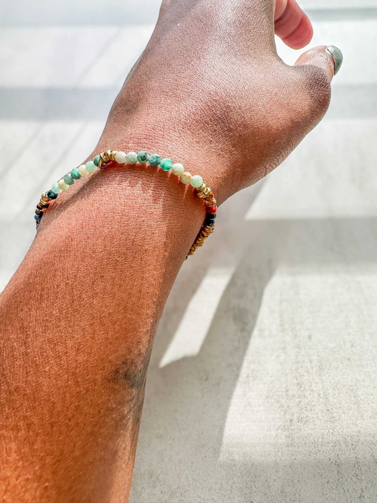 Aether natural gemstone bracelet on wrist with emerald, pietersite and rainbow moonstone