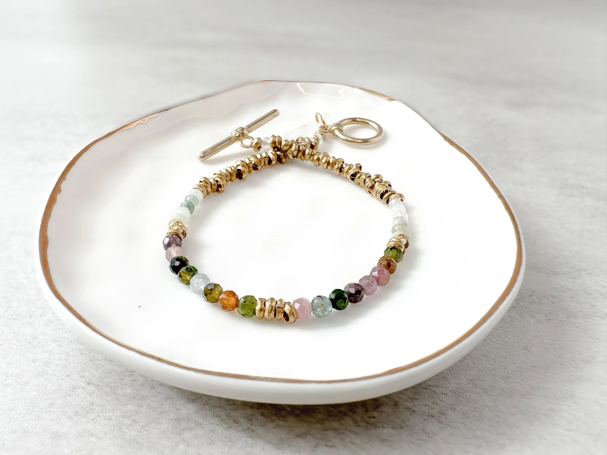Arden natural gemstone bracelet on dish, watermelon tourmaline, Burmese jade and rainbow moonstone beads