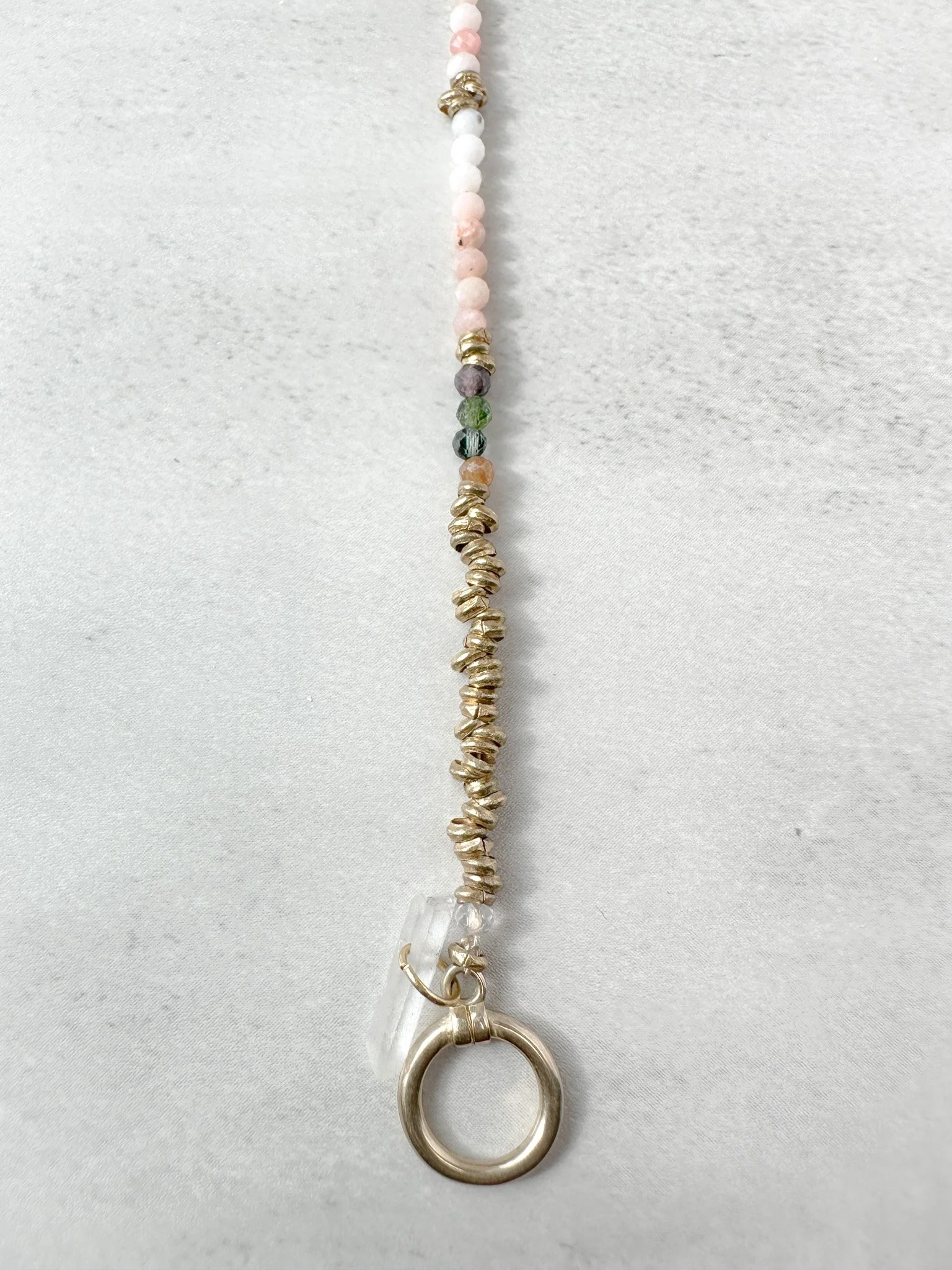 Close-up of Aurora bracelet Ethiopian brass heishi beads with toggle clasp and clear quartz charm