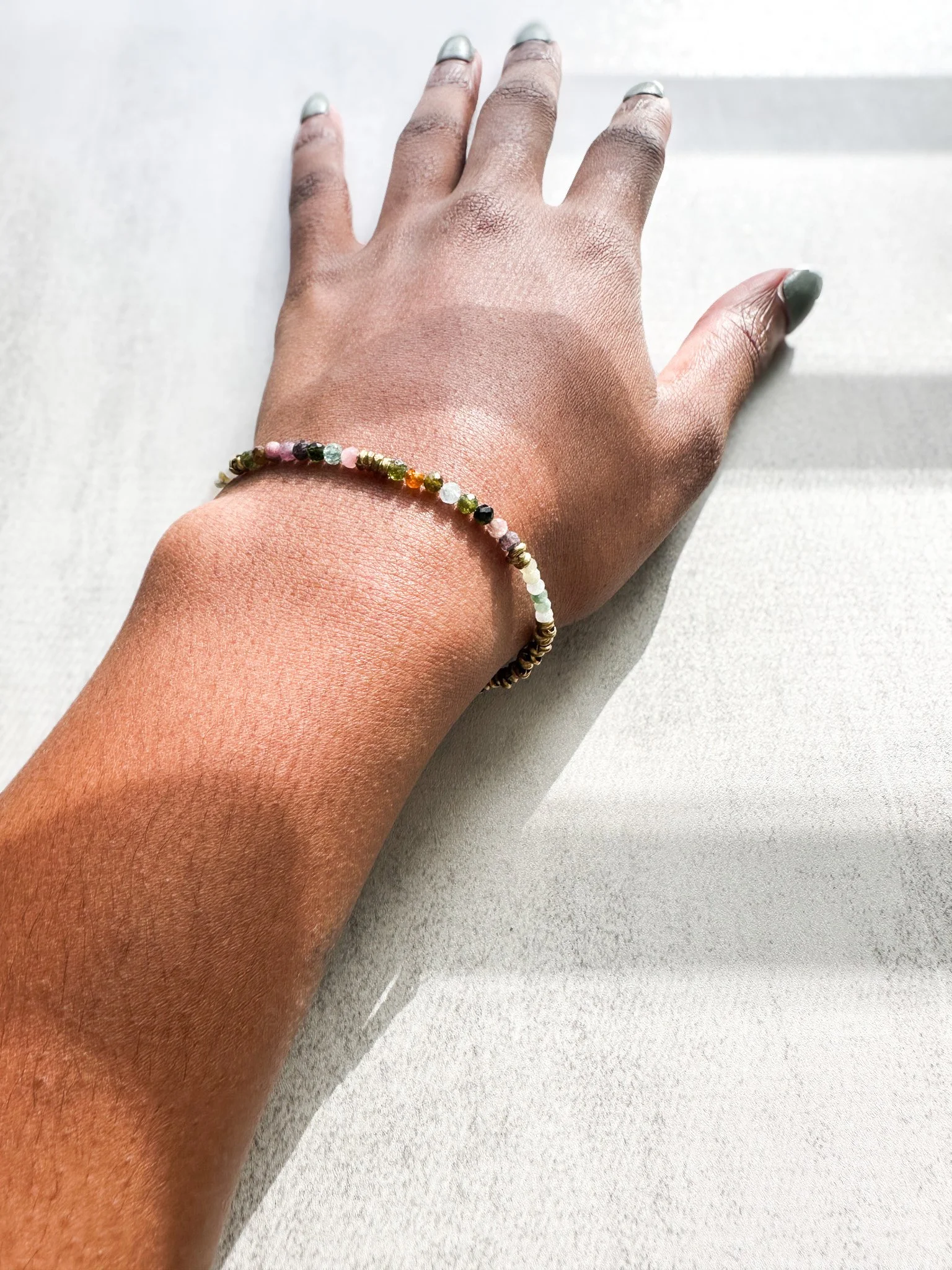 Arden natural gemstone bracelet on wrist with watermelon tourmaline, Burmese jade and rainbow moonstone