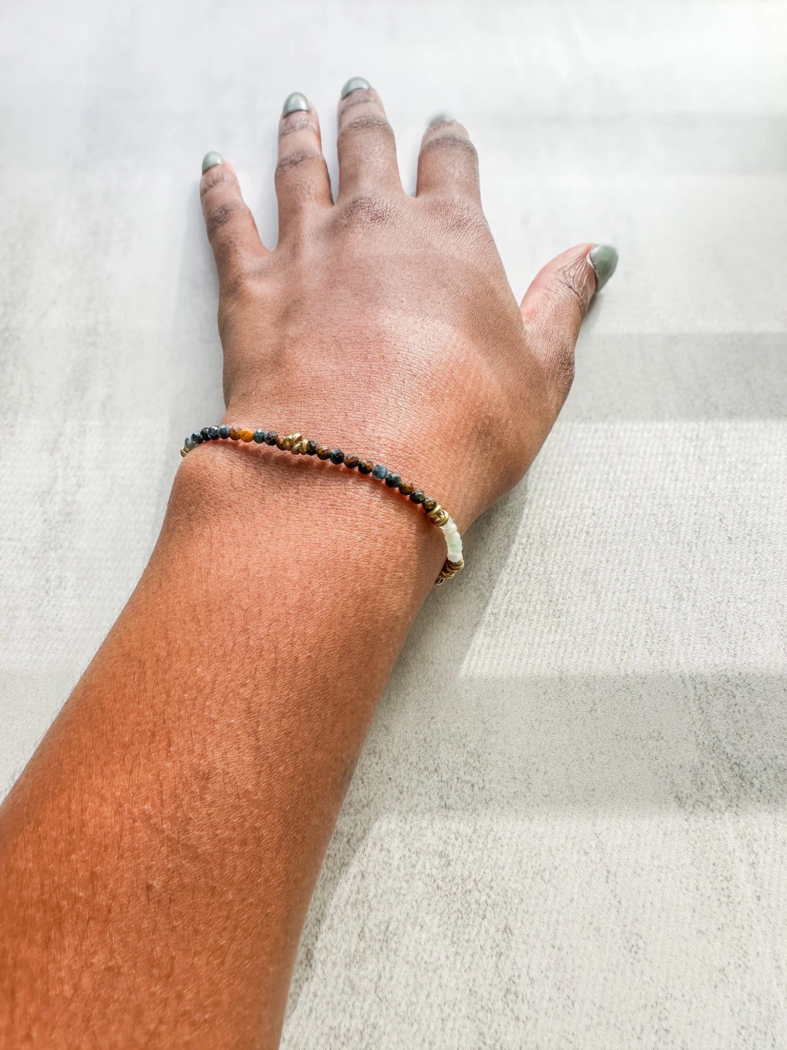 Tempest natural gemstone bracelet on wrist with pietersite jade and rainbow moonstone