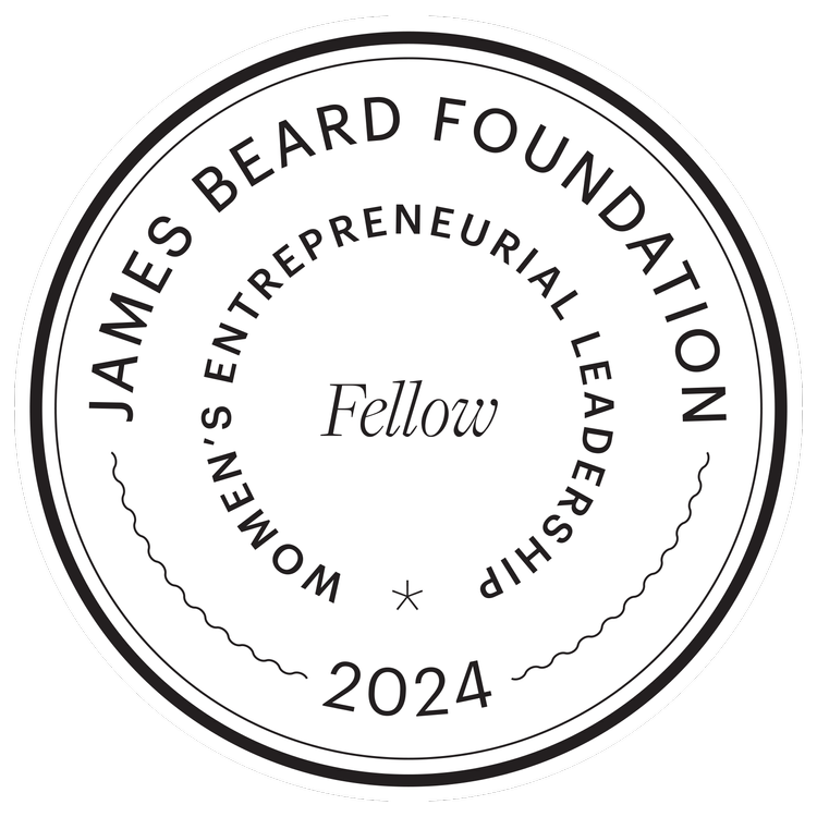 Circular emblem with the text 'WOMEN'S ENTREPRENEURIAL LEADERSHIP' and 'JAMES BEARD FOUNDATION' around the top, 'Fellow' in the center, and '2024' at the bottom, all in black on white background.