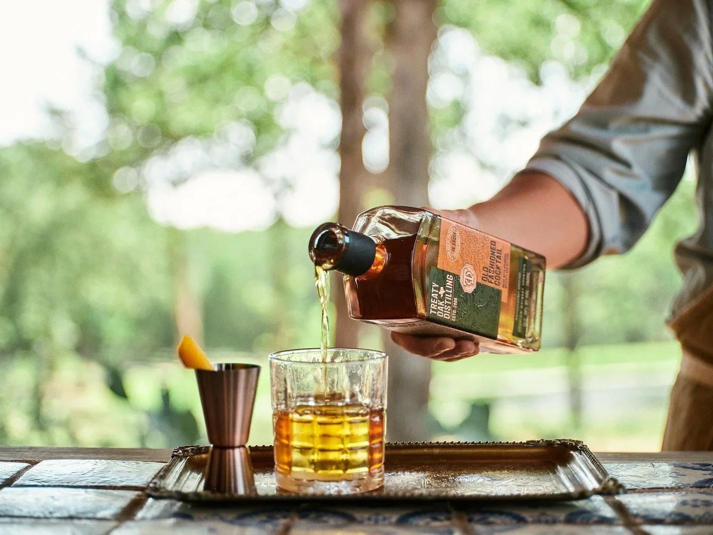 Treaty Oak Distilling pouring whiskey outdoors.jpg