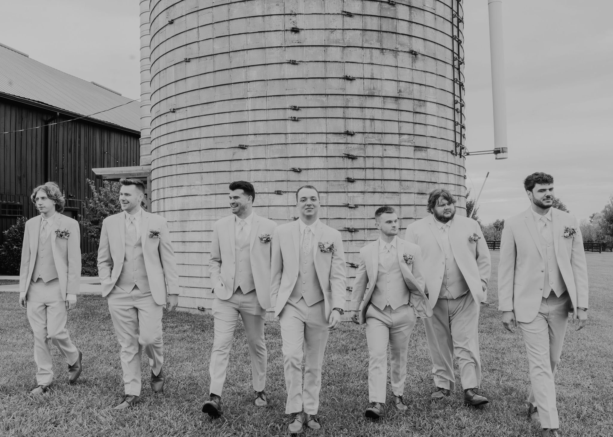 Groomsman in front of silo at Evan's Orchard