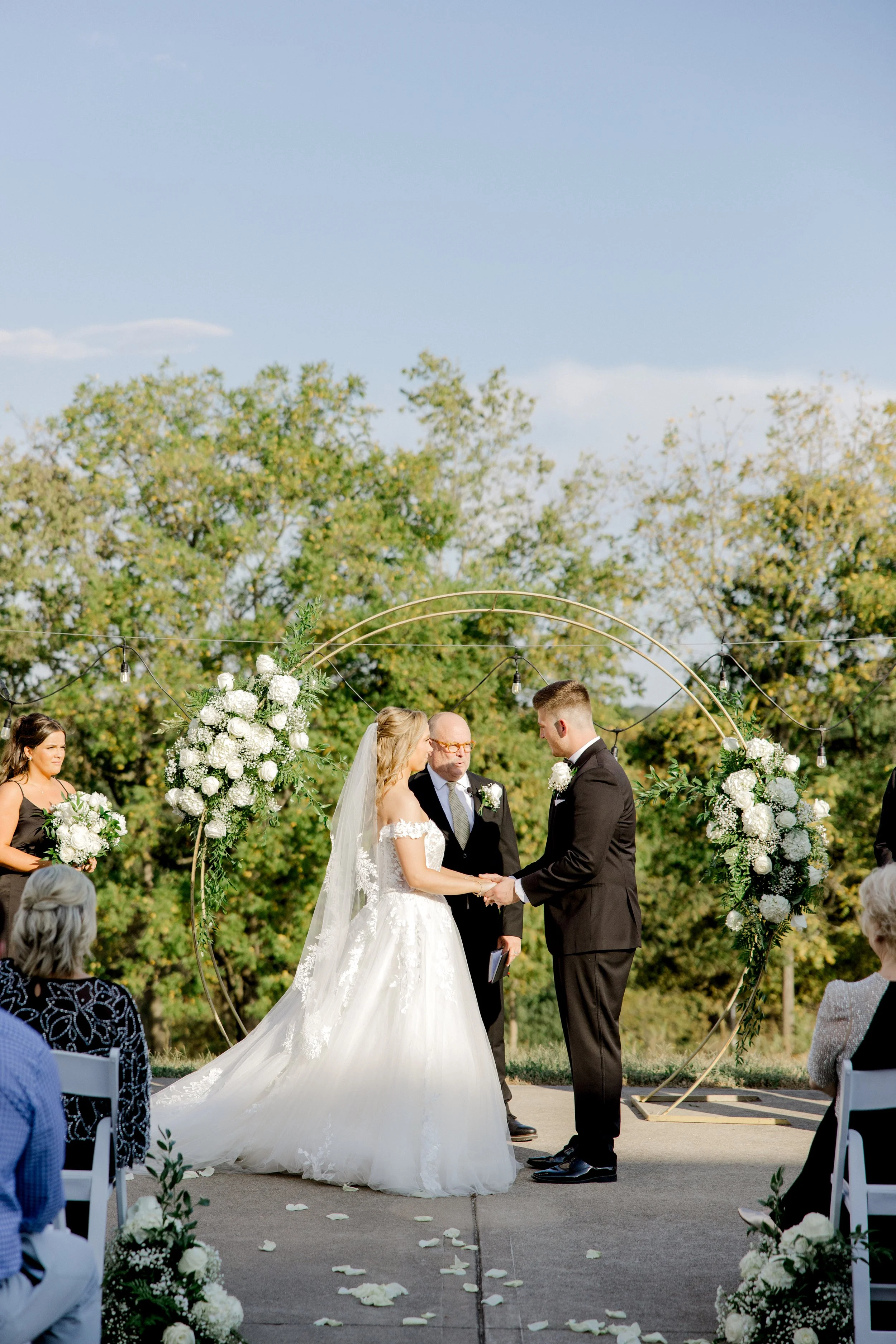 Outdoor wedding ceremony under a floral arch at One Oak in Nicholasville, Kentucky