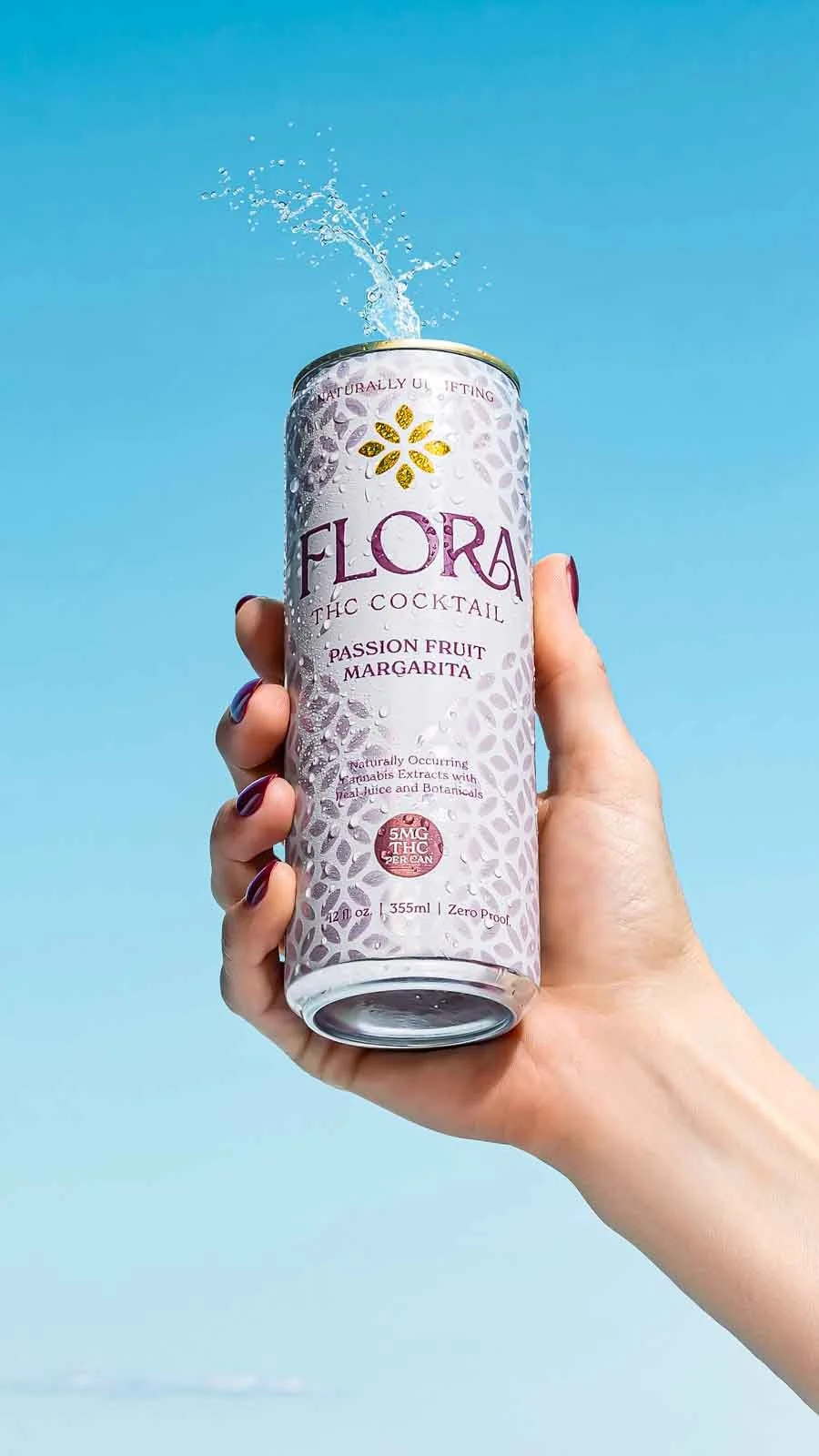 hand-holding-cold-canned-beverage-against-blue-sky.jpg