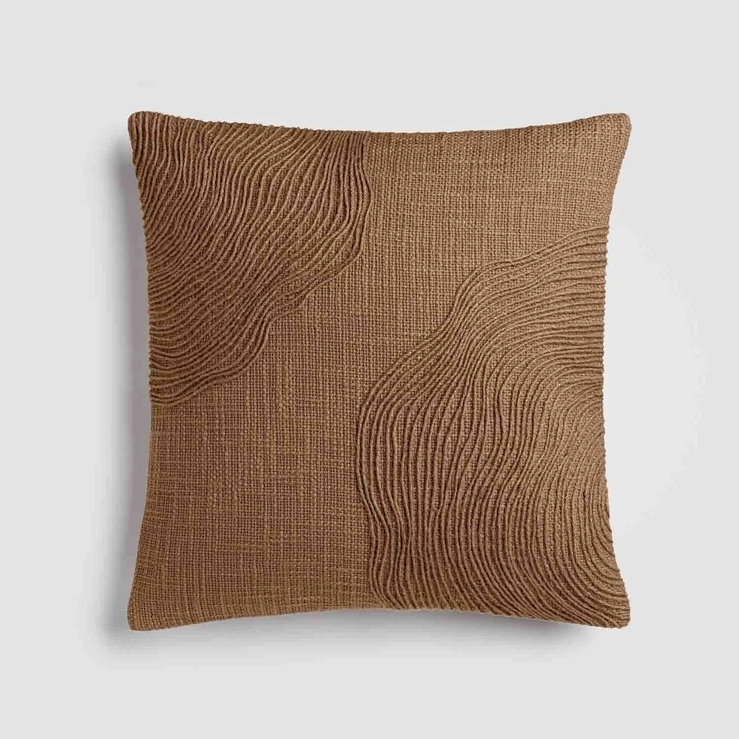 Brown decorative throw pillow with textured wavy pattern on a plain light background.