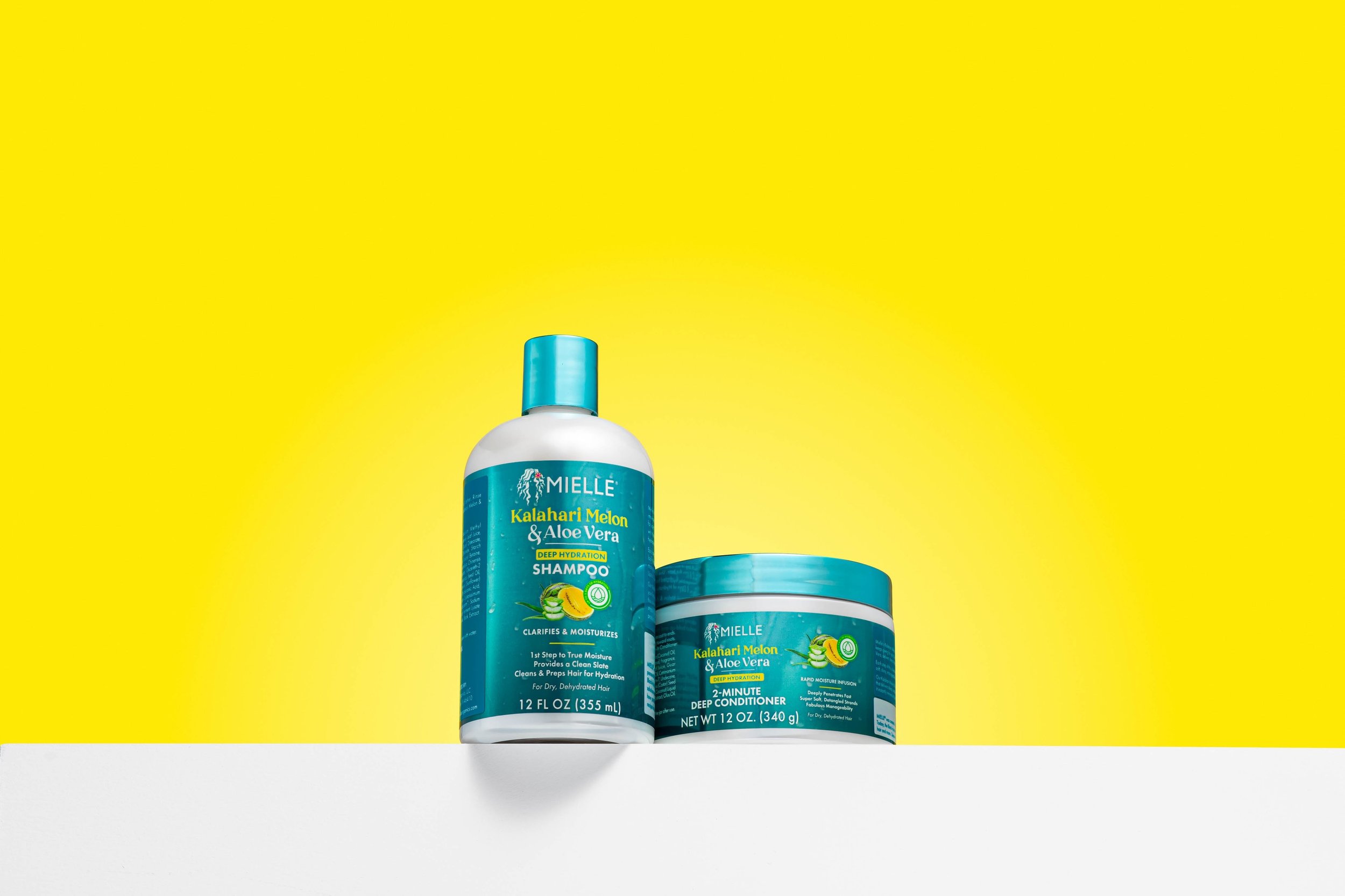 Mielle Kalahari Melon & Aloe Vera shampoo and conditioner on yellow background