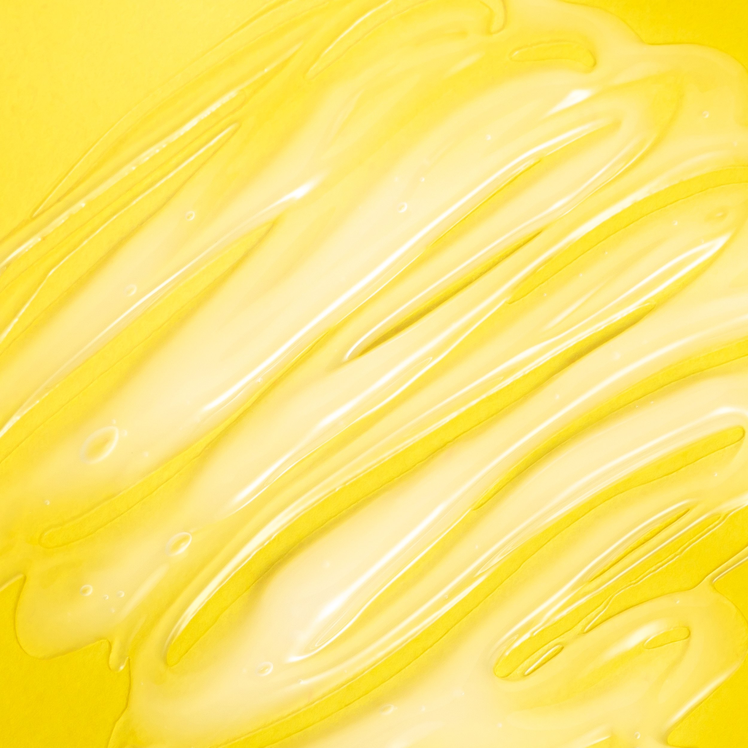 Swirls of clear gel on yellow background
