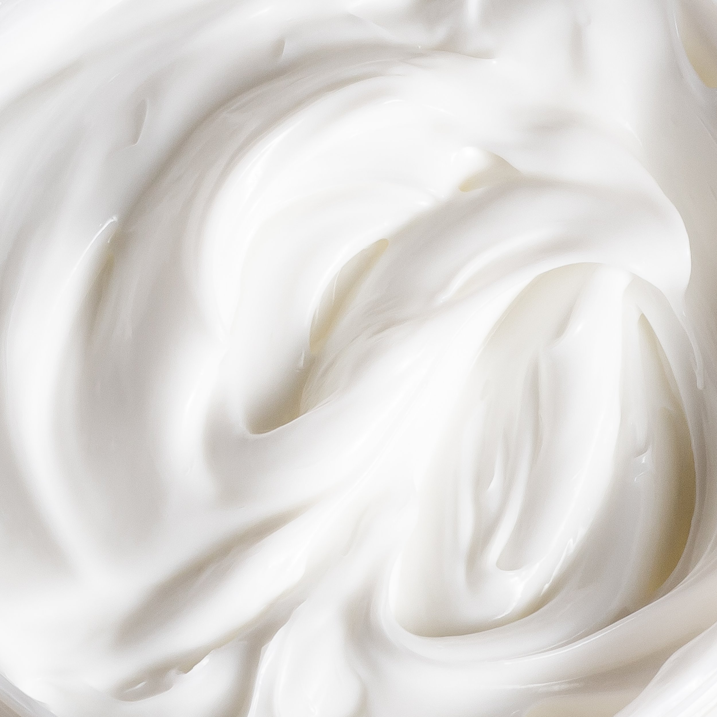 Close-up of smooth, creamy white yogurt texture with swirls.