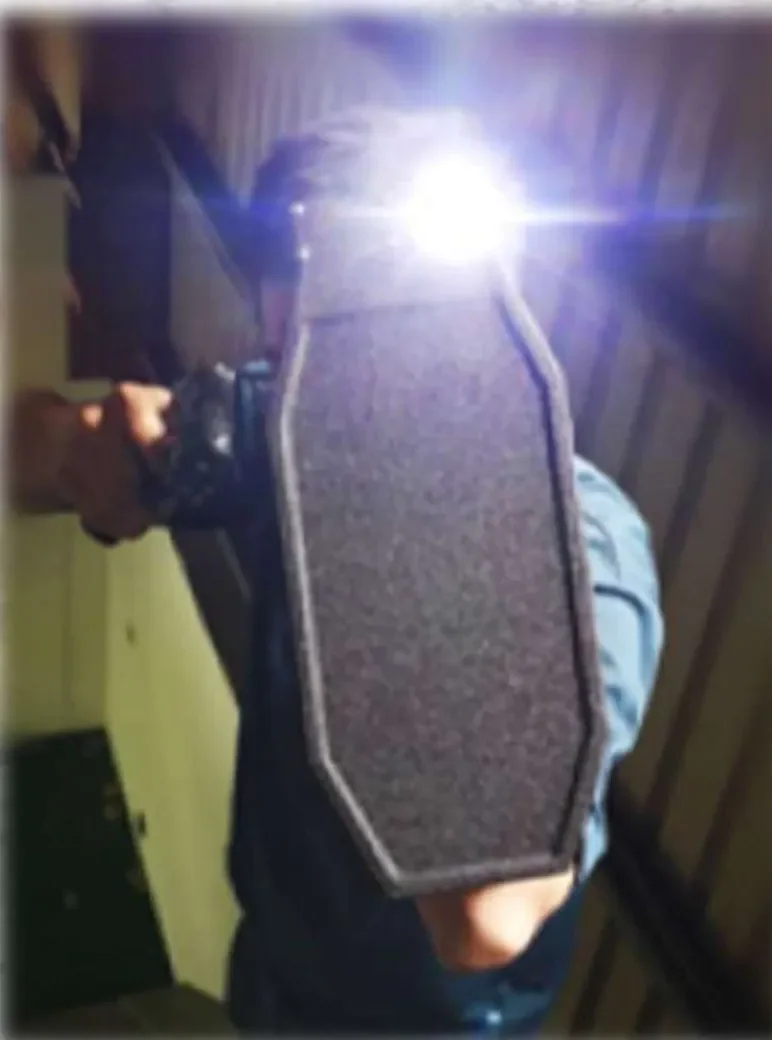 He carries a bulletproof shield and a flashlight.