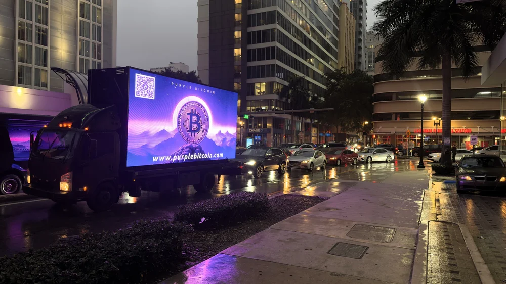 Mobile LED billboard truck displaying a Purple Bitcoin advertisement at night in South Florida