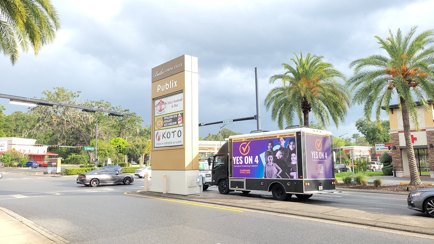 Mobile billboard truck running a community campaign on a busy street