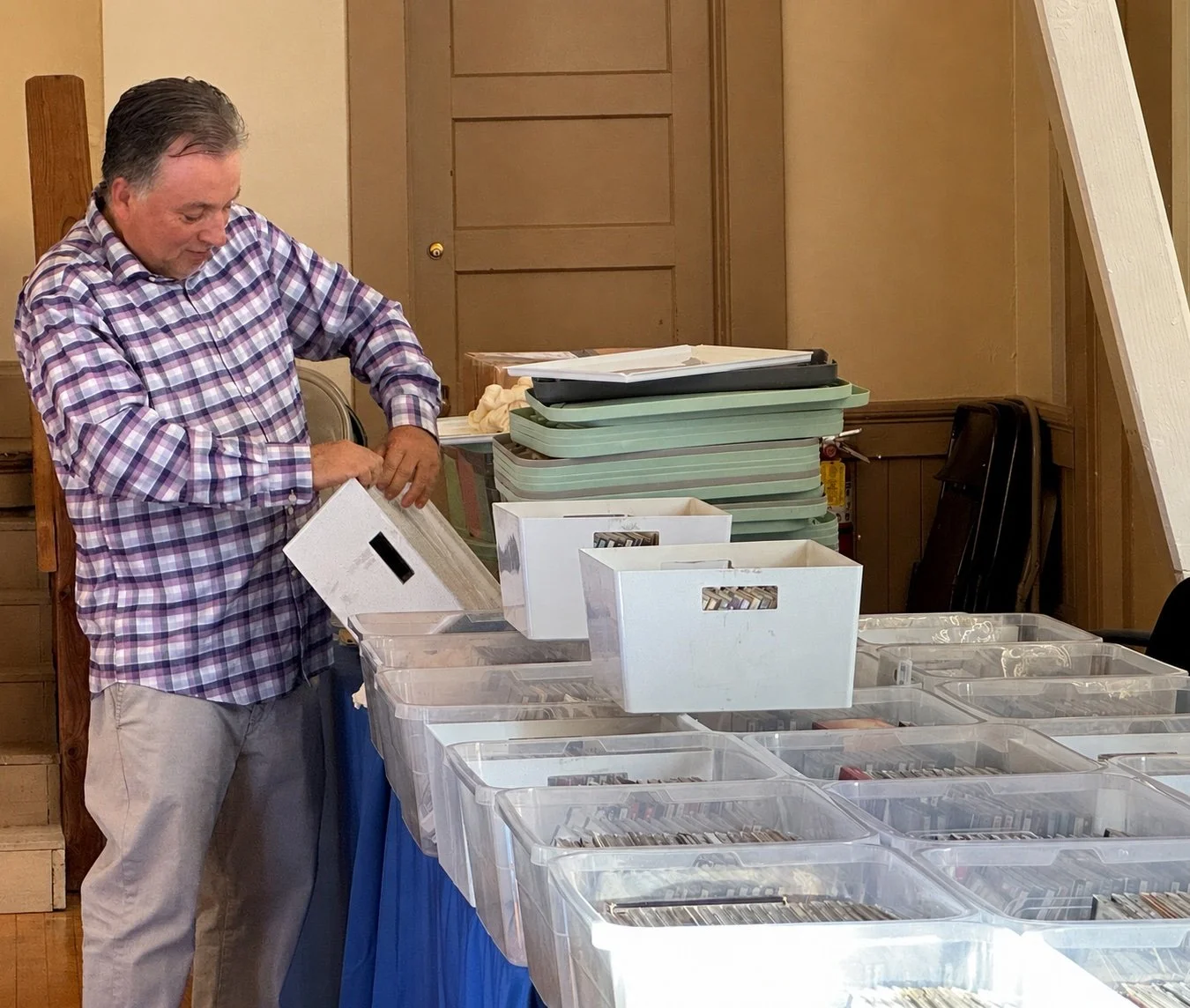 Proprietor organizing bins of music CDs