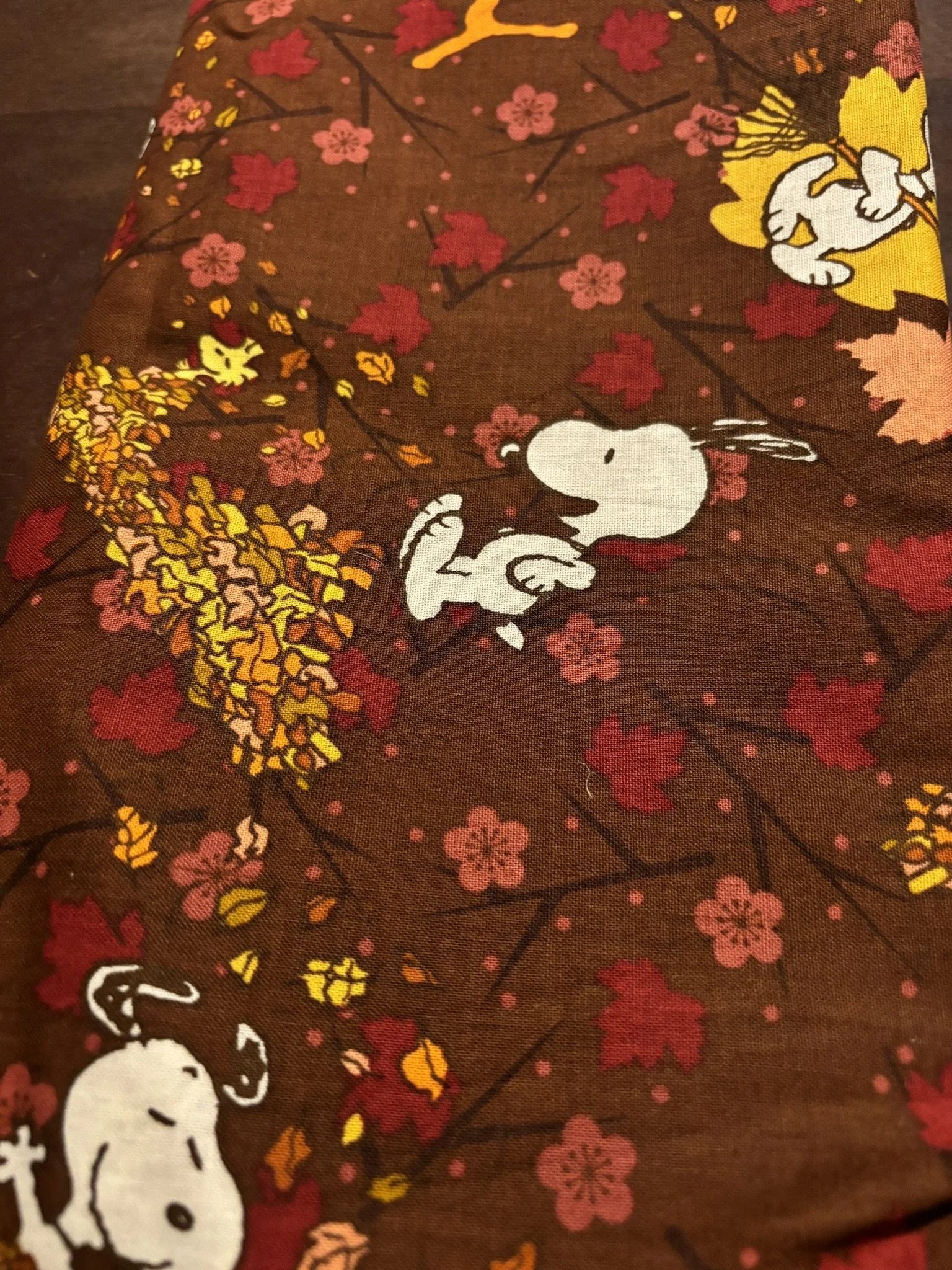 Snoopy Jumping in Leaves on Brown Cotton.JPEG