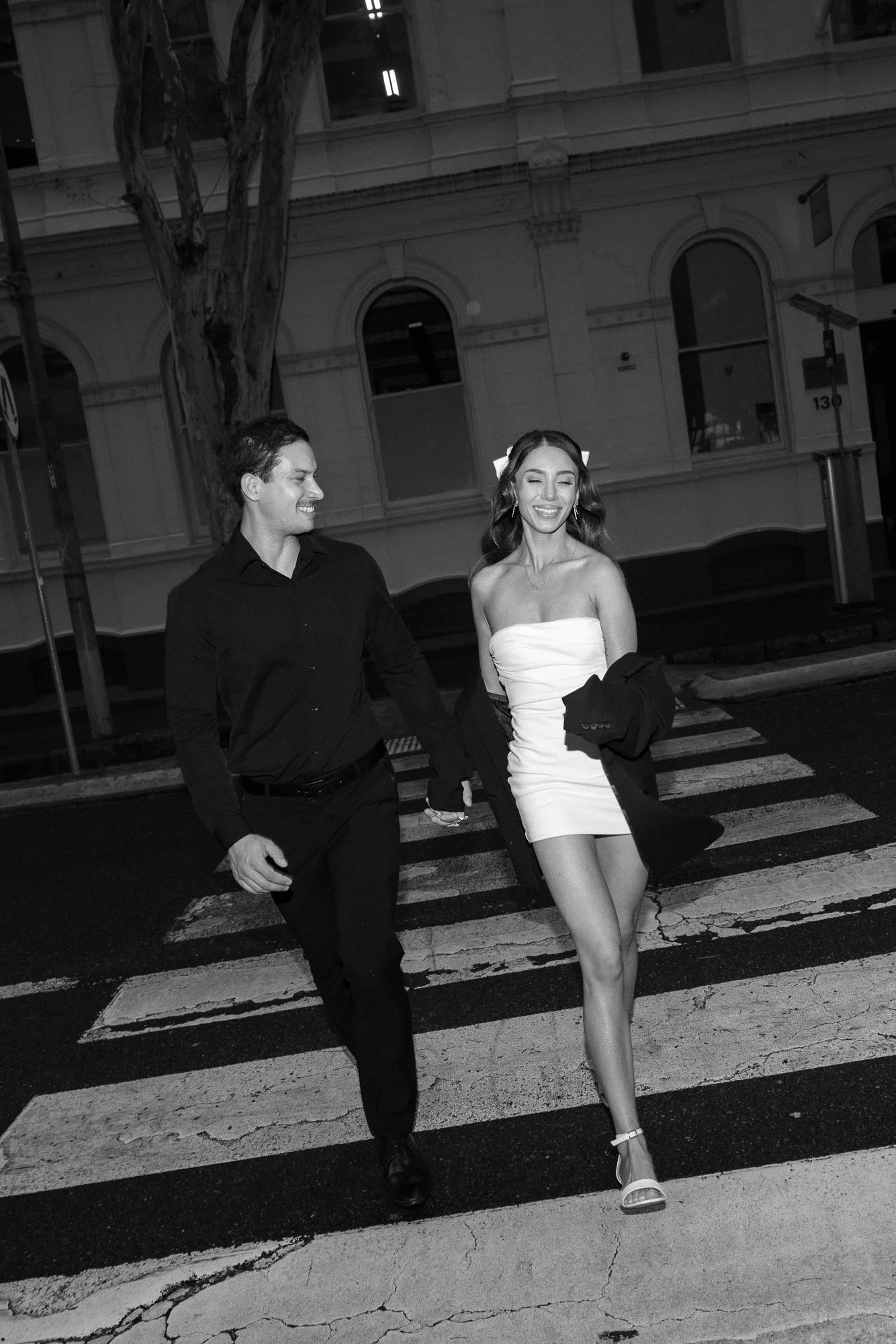 Engaged couple smiling together crossing the road in Brisbane CBD