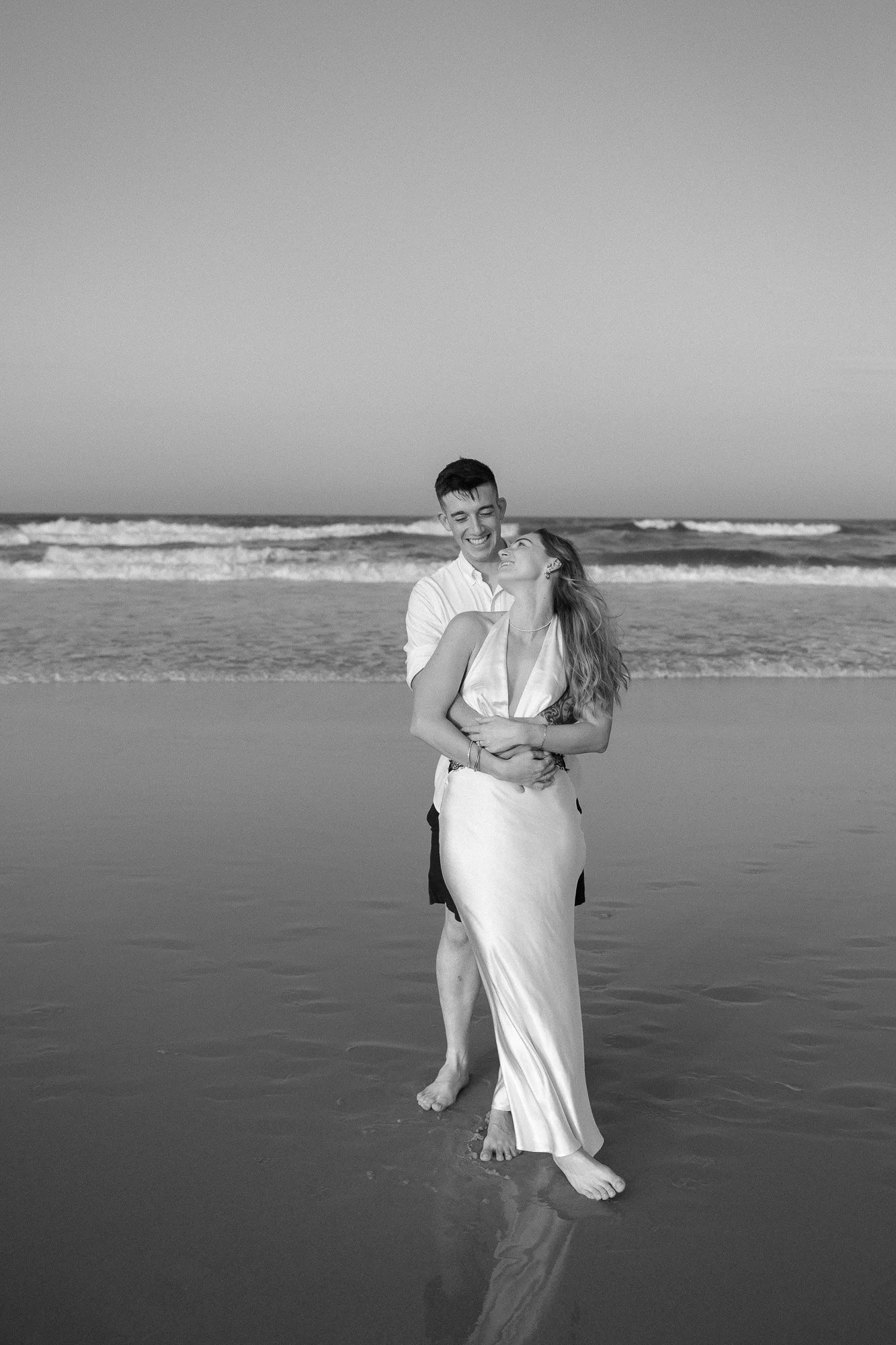 Brisbane couple laughing during their engagement photoshoot at Currumbin Beach