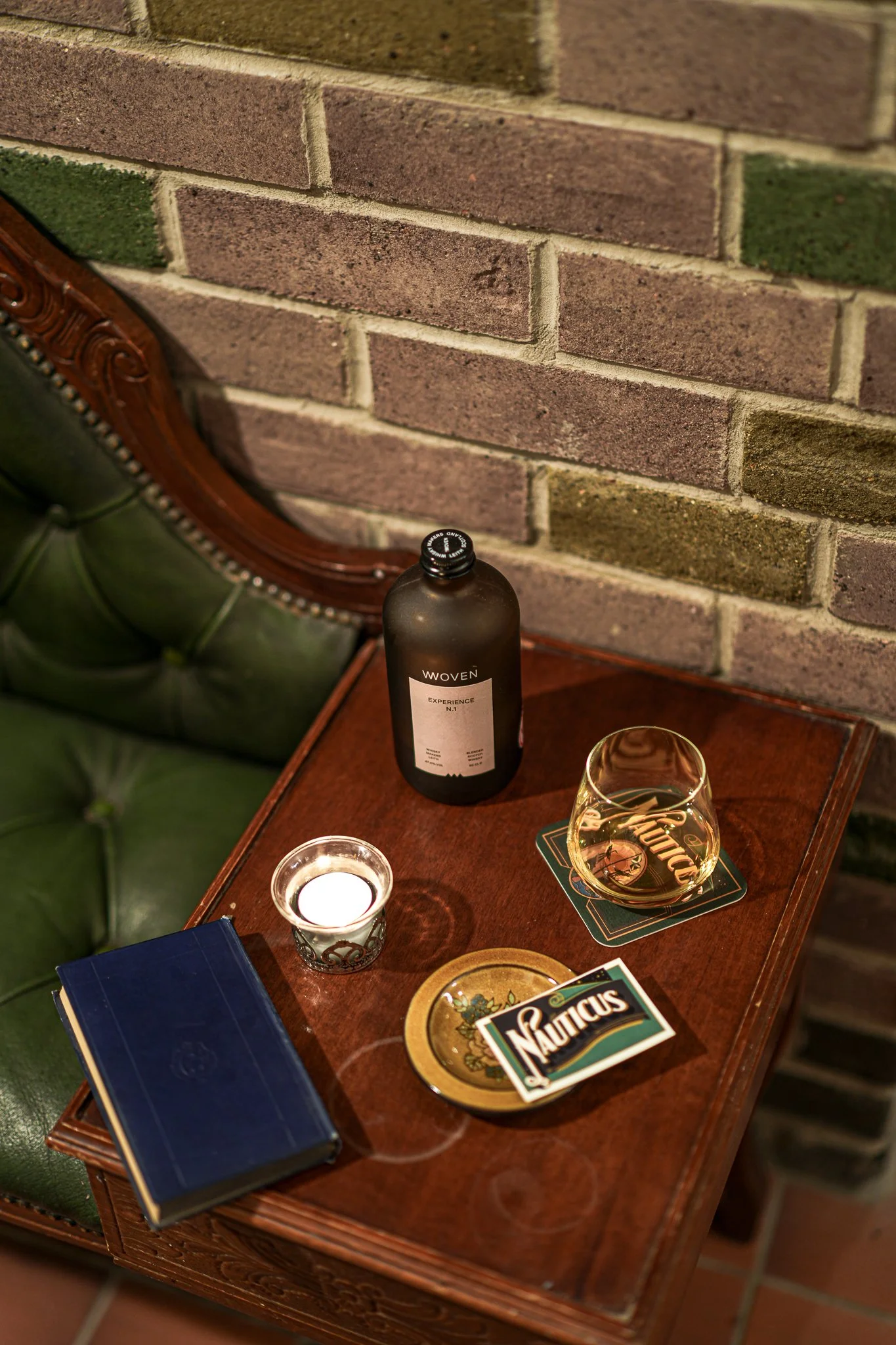 Table with whisky glass next to low carbon wall