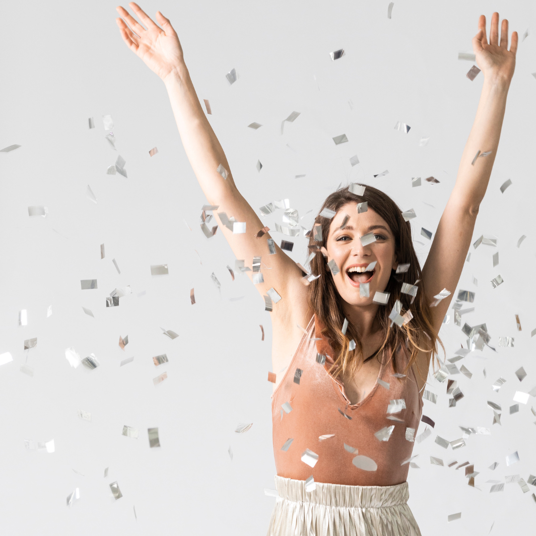 Woman throwing confetti in the air with her arms in he air smiling. Stripe Social Pinterest Power Hour.