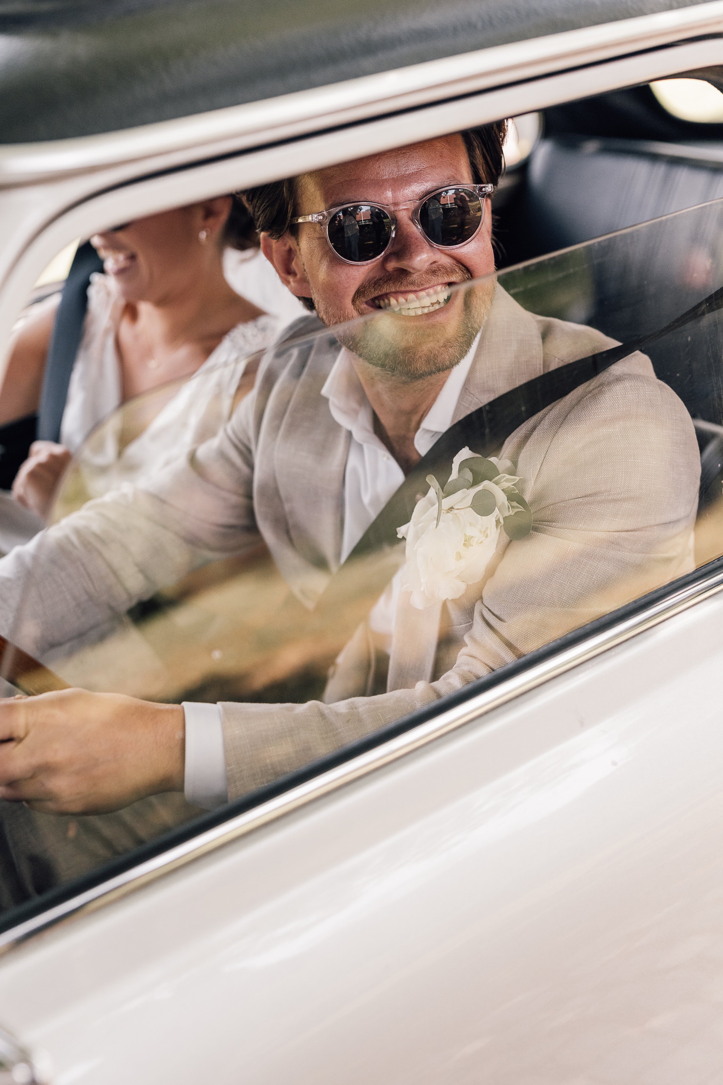 Gommen sidder i bilen. Bryllup på Møllerup Gods