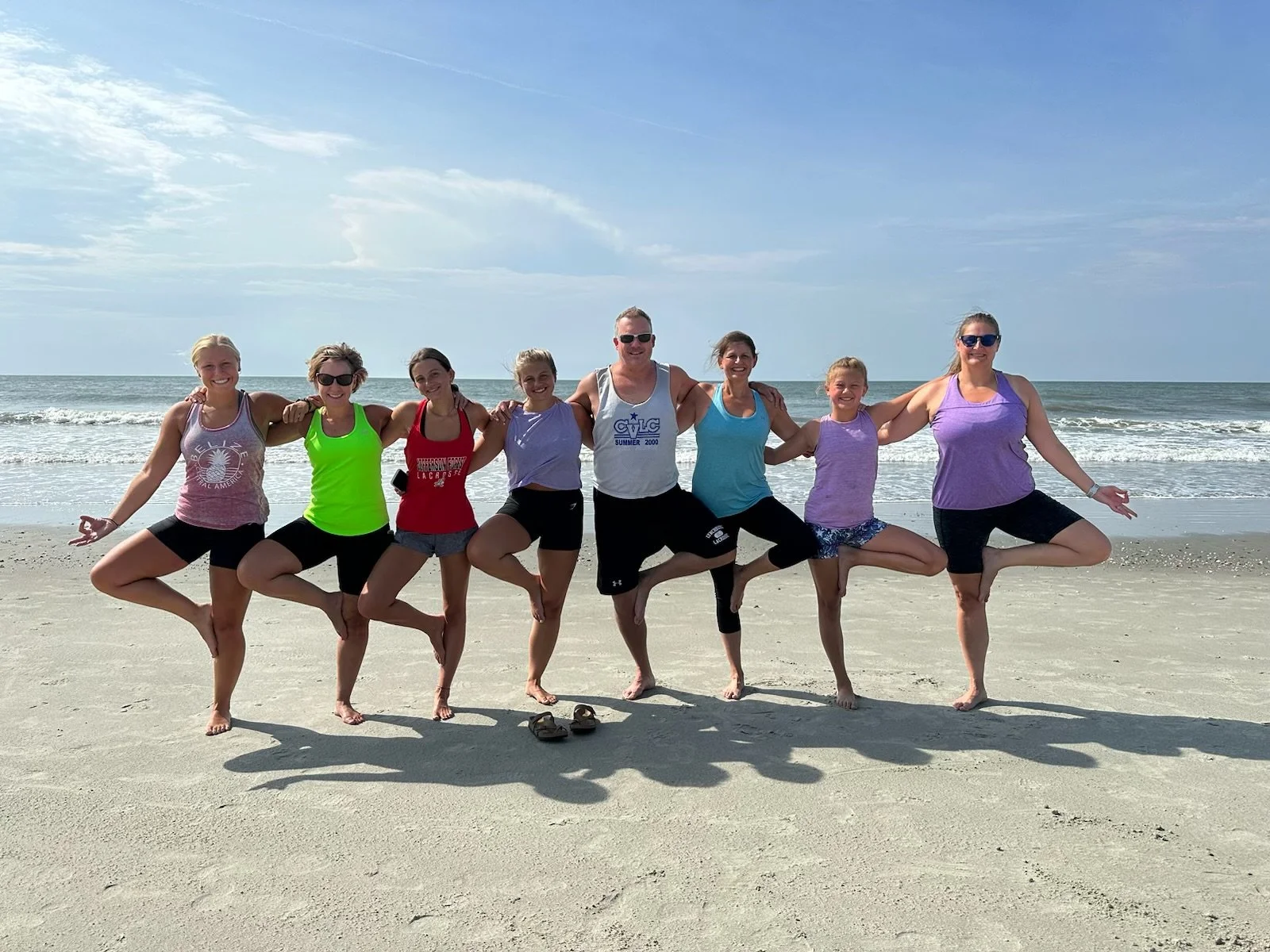 Family enjoying a private beach yoga session on Isle of Palms near Charleston, South Carolina. Serenity Tree Yoga offers customized yoga experiences for families and vacation groups of all ages.