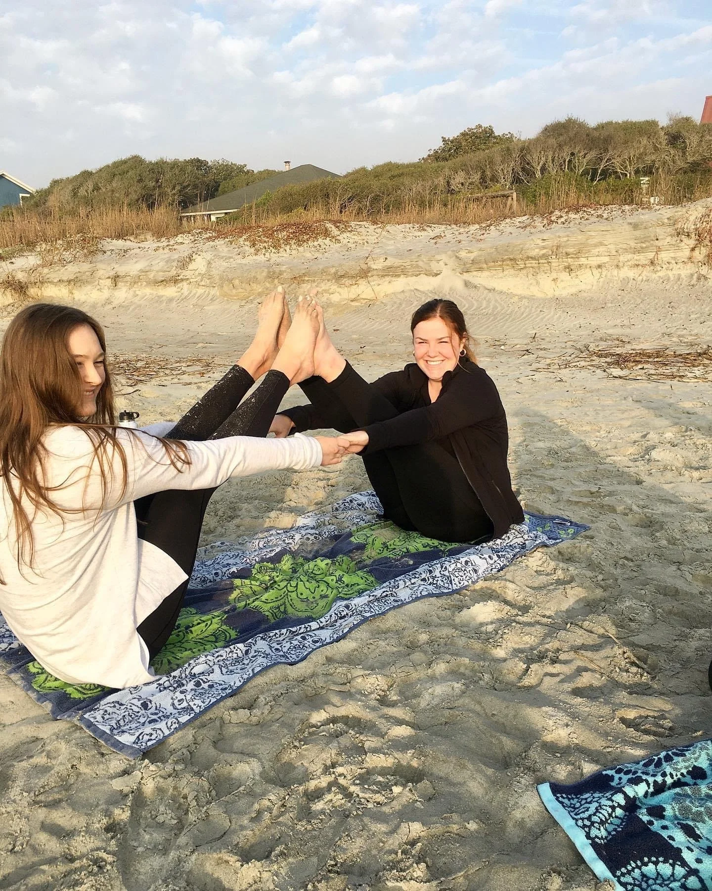 Coworkers enjoying a private beach yoga session as part of a team-building experience in Charleston, South Carolina.