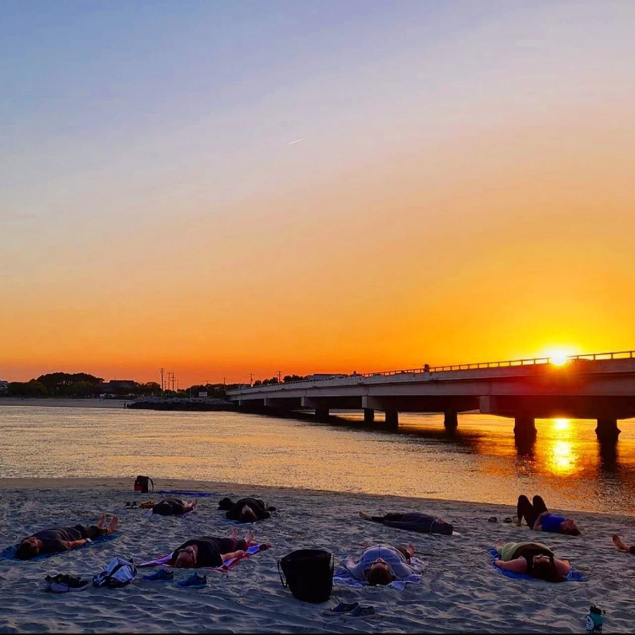 Sunset community beach Yoga class at Breach Inlet on Isle of Palms near Charleston, South Carolina.