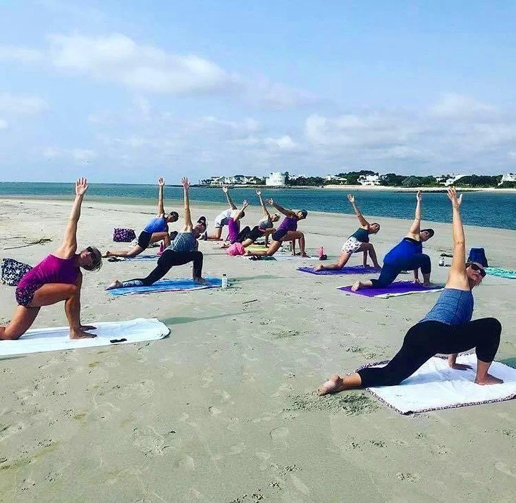 Community beach yoga class at Breach Inlet on Isle of Palms near Charleston, South Carolina.