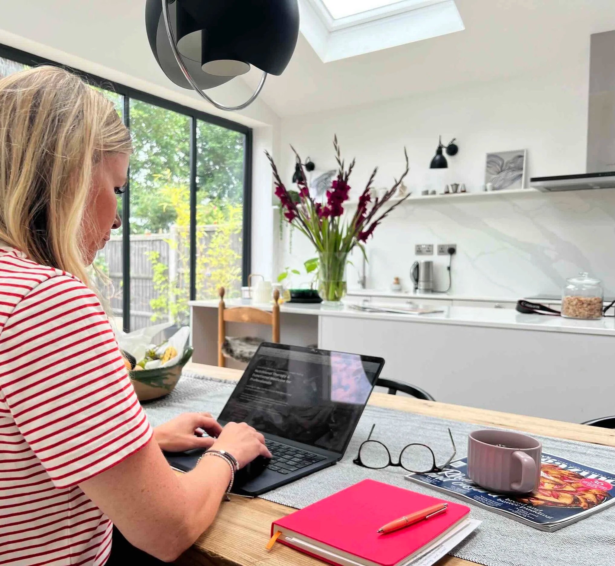 Nutritionist working on computer in modern kitchen