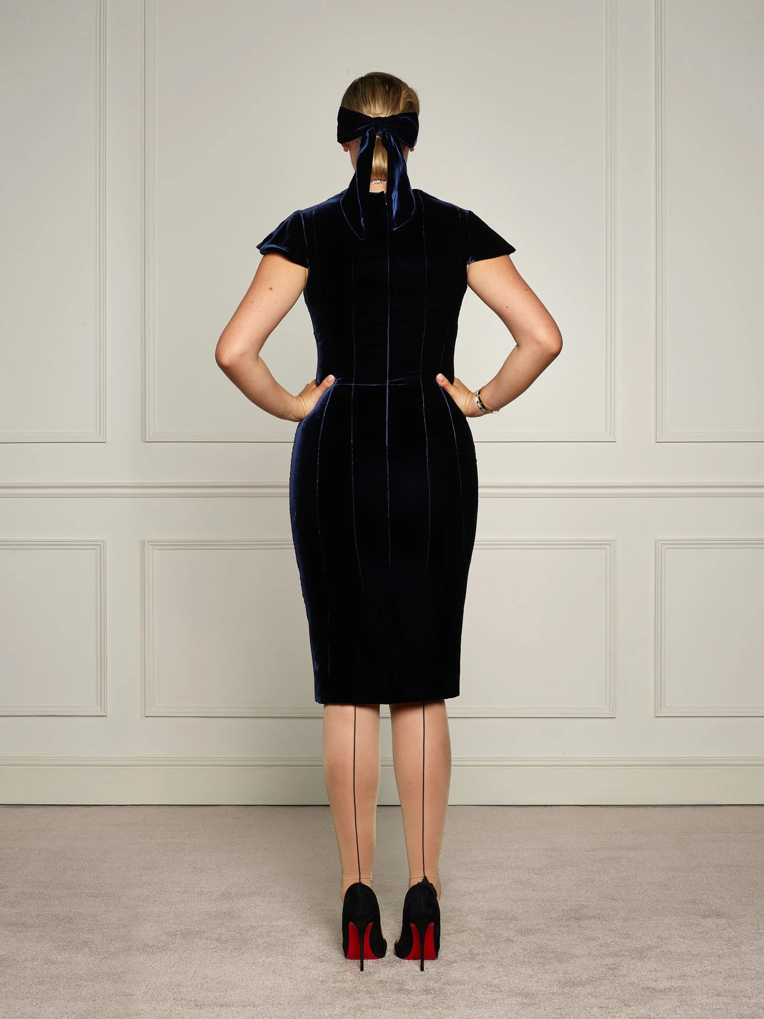 Back view of Paget London navy velvet corset midi dress, showcasing fitted waist and clean tailored lines