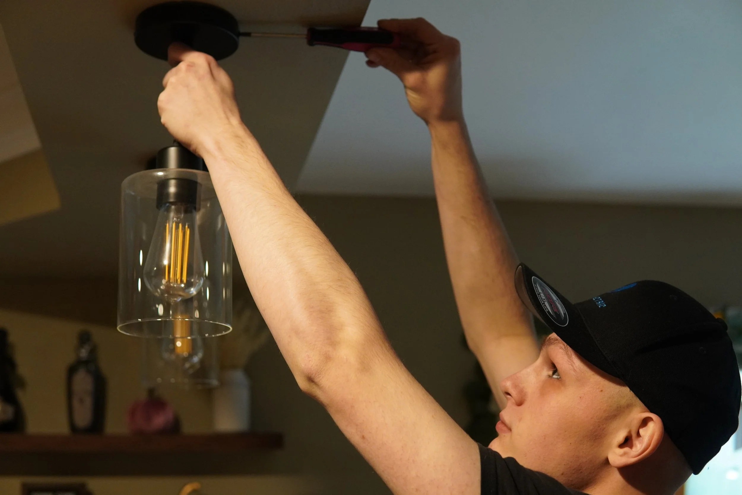 electrician replacing pendant light in kitchen